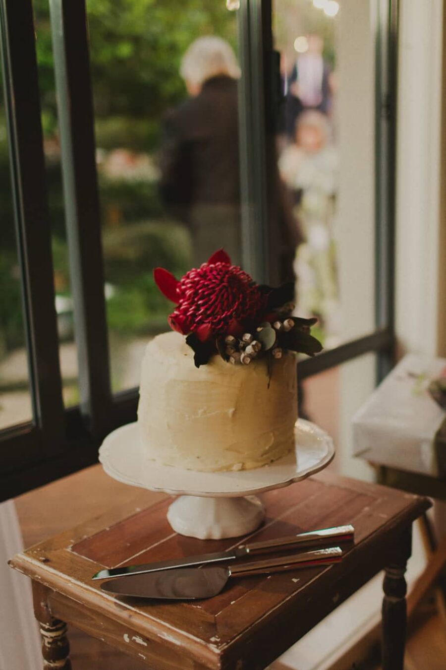 simple wedding cake with waratah topper