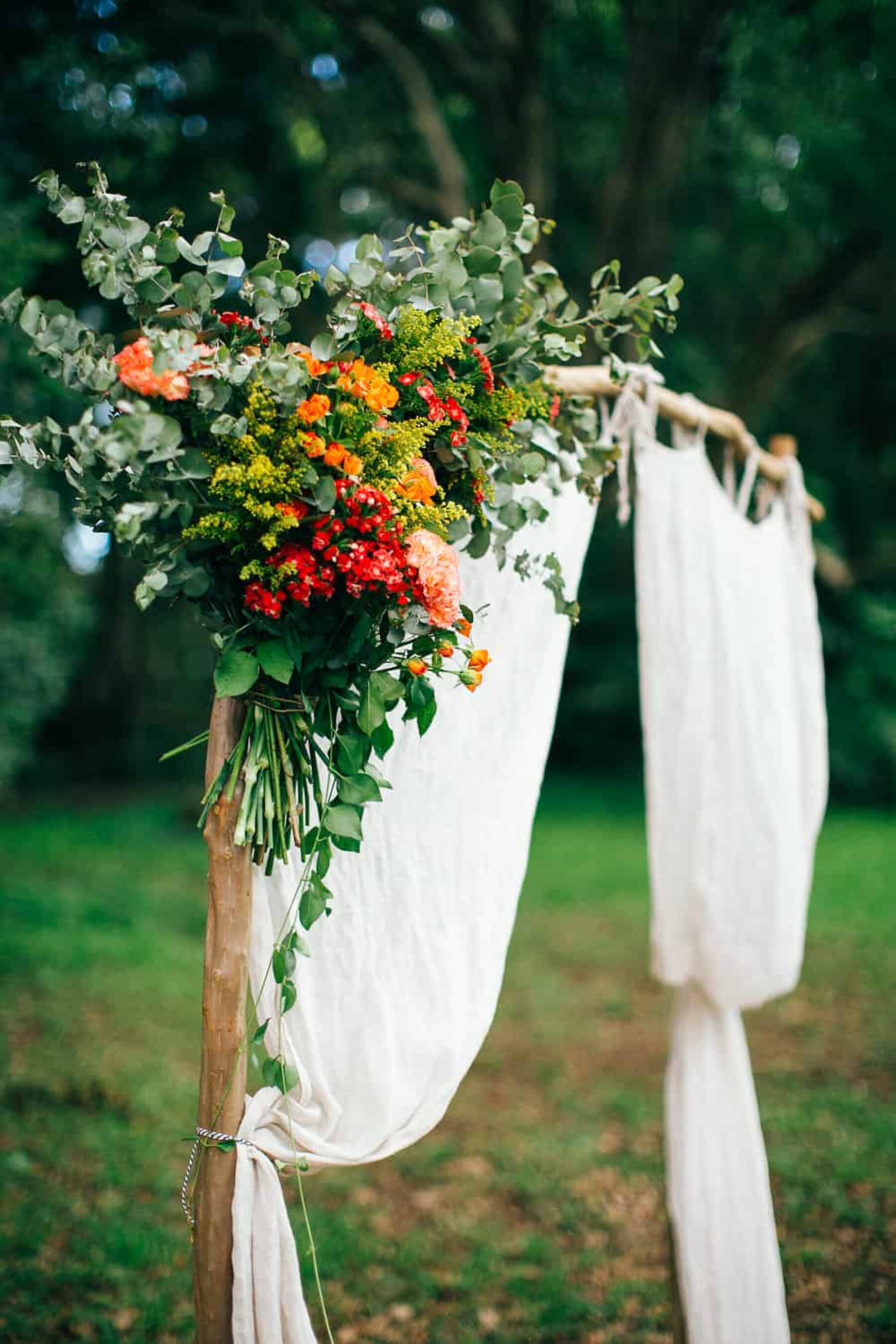 draped curtain wedding arbour with floral cluster