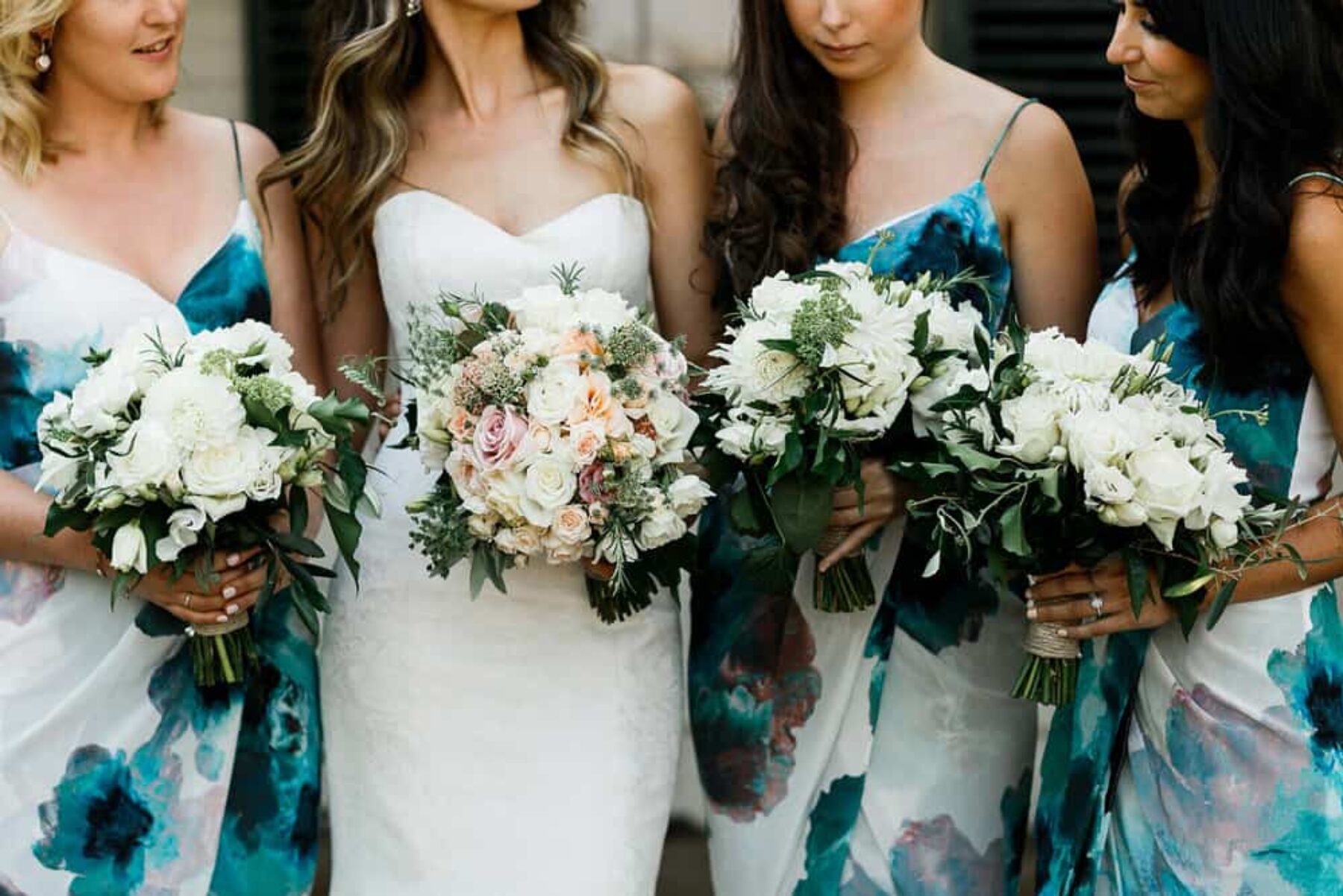 bridesmaids in blue floral print dresses and classic bouquets