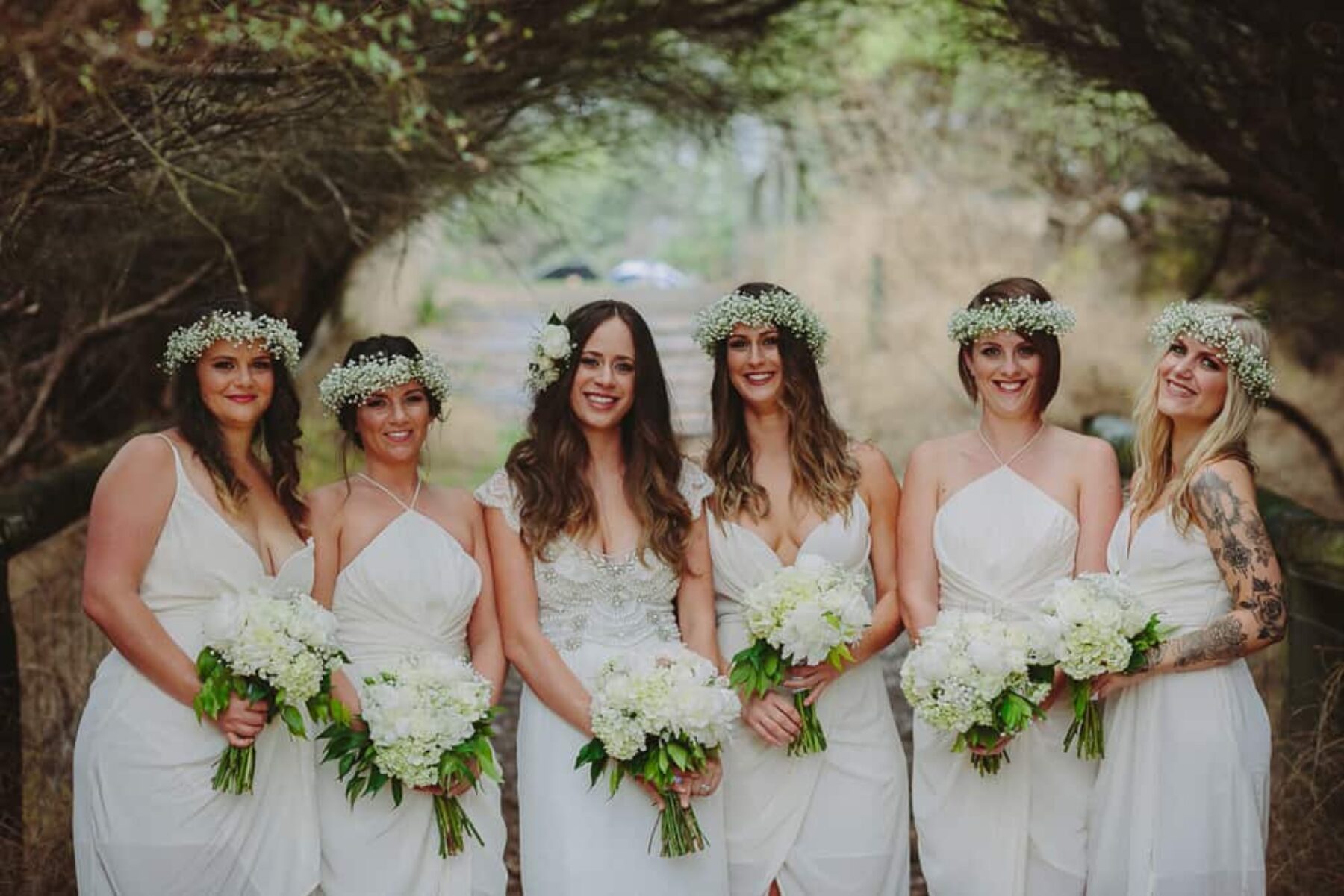 bridesmaids in white Zimmermann dresses and baby's breath flower crowns