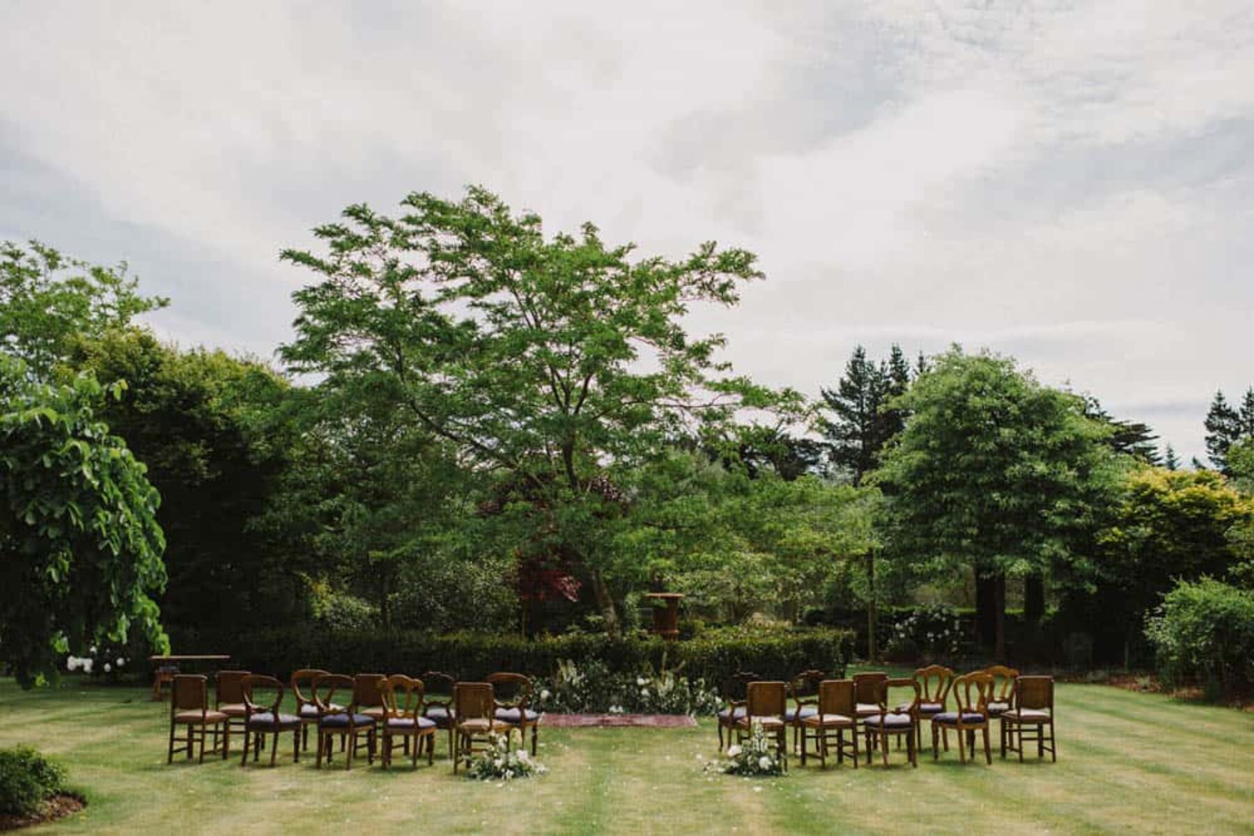 bohemian garden wedding ceremony with vintage chairs