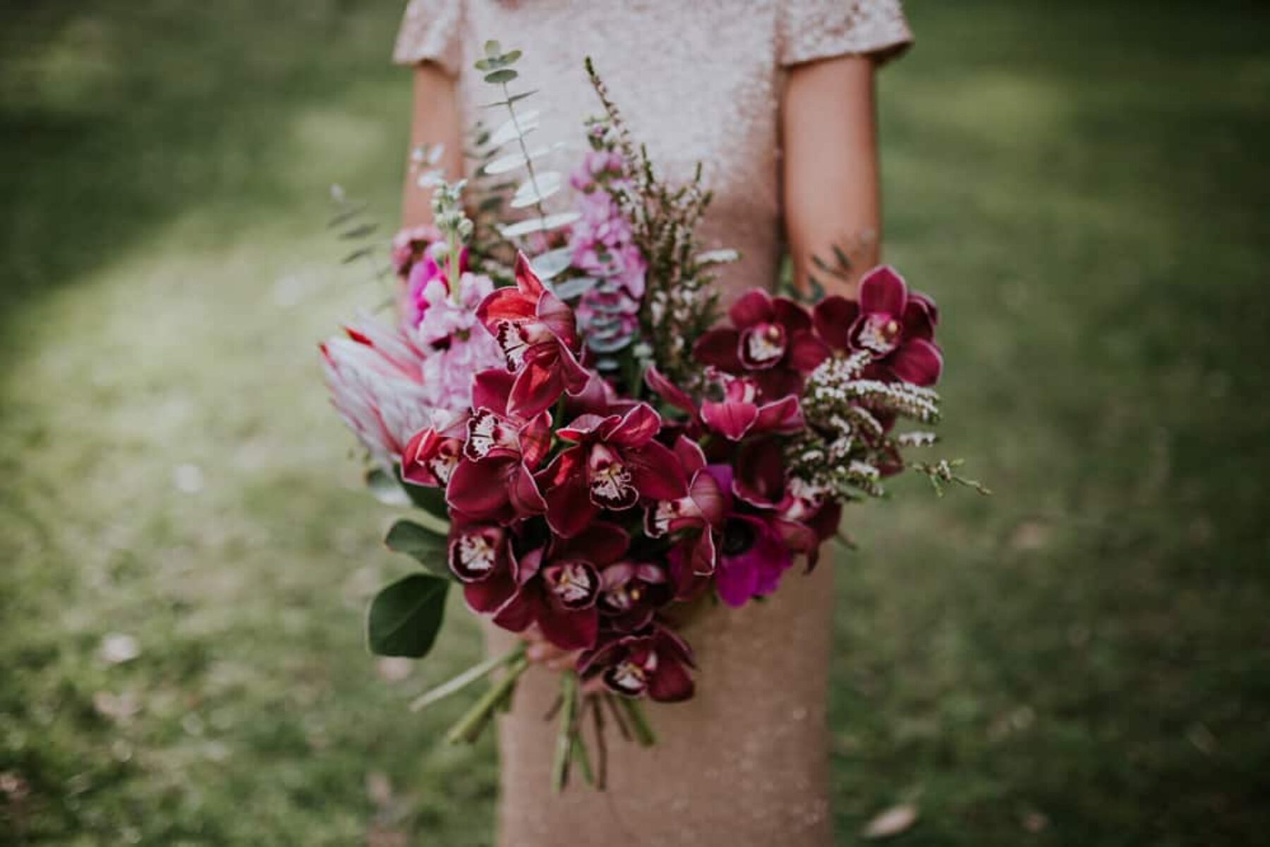 magenta wedding bouquet with orchids and protea