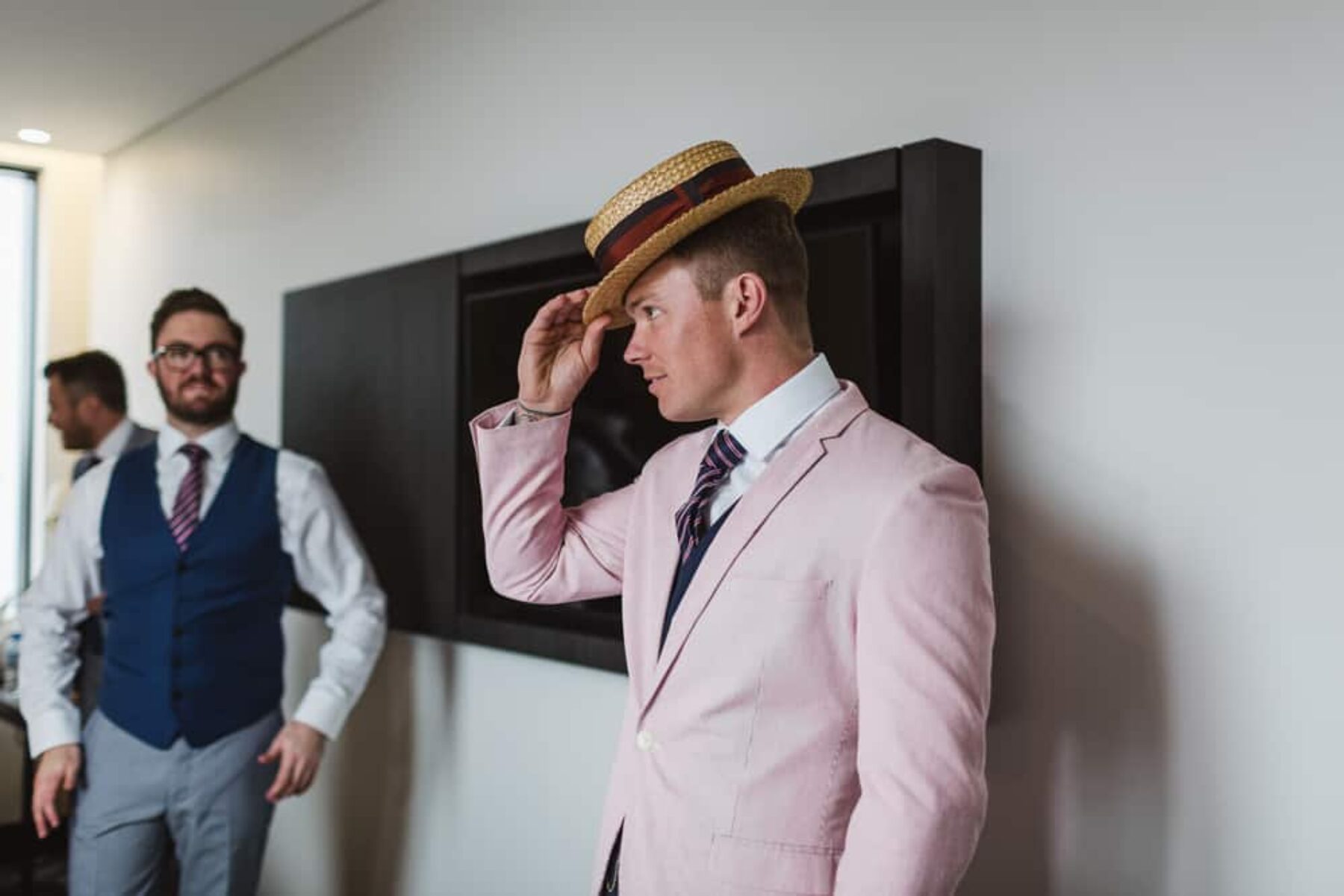 groom in pink suit and boater hat