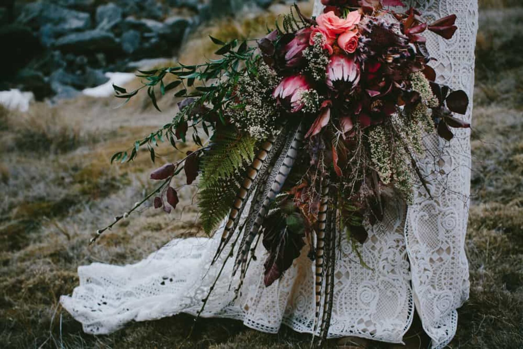 boho wedding bouquet with protea and feathers