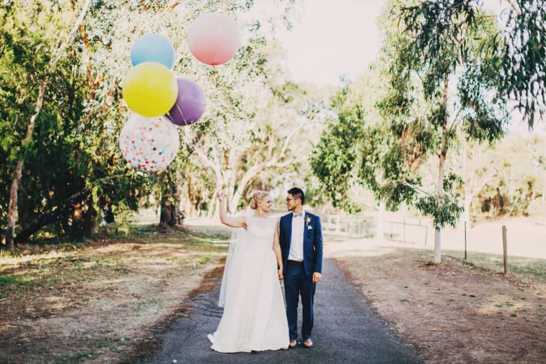 bride and groom with giant colour balloons