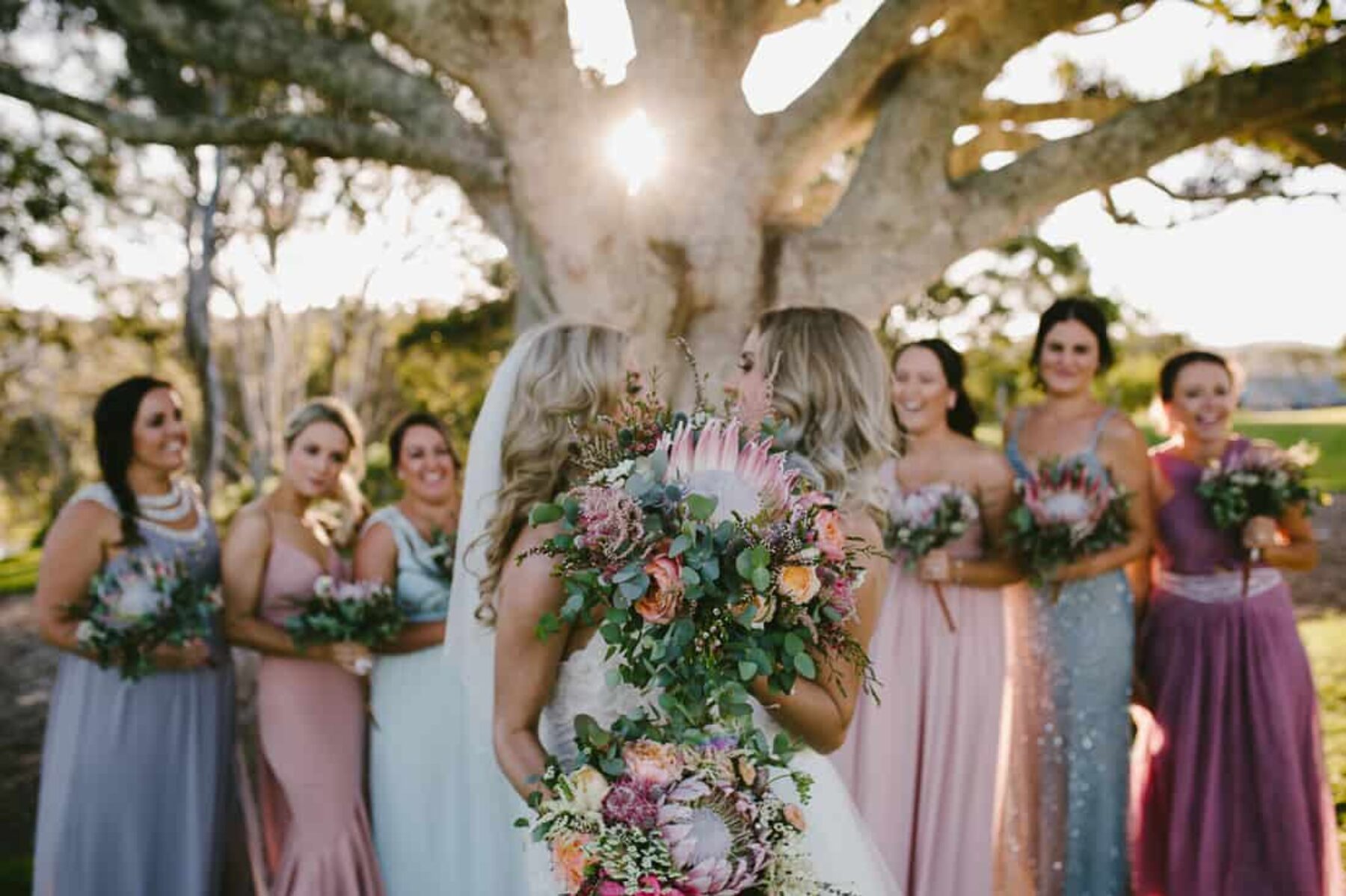 brides and bridesmaids with protea bouquets
