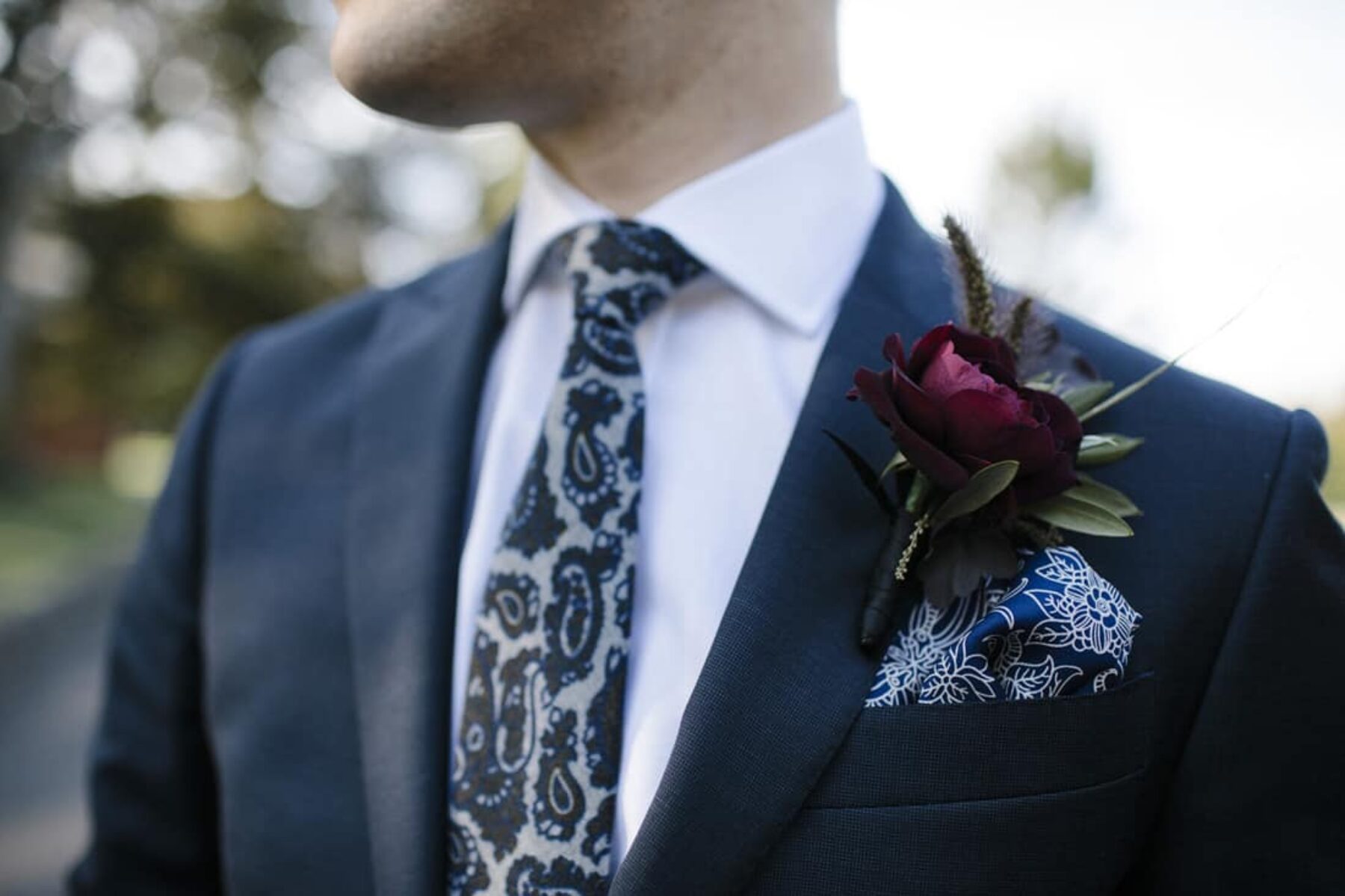 Stylish groom with paisley tie and pocket square