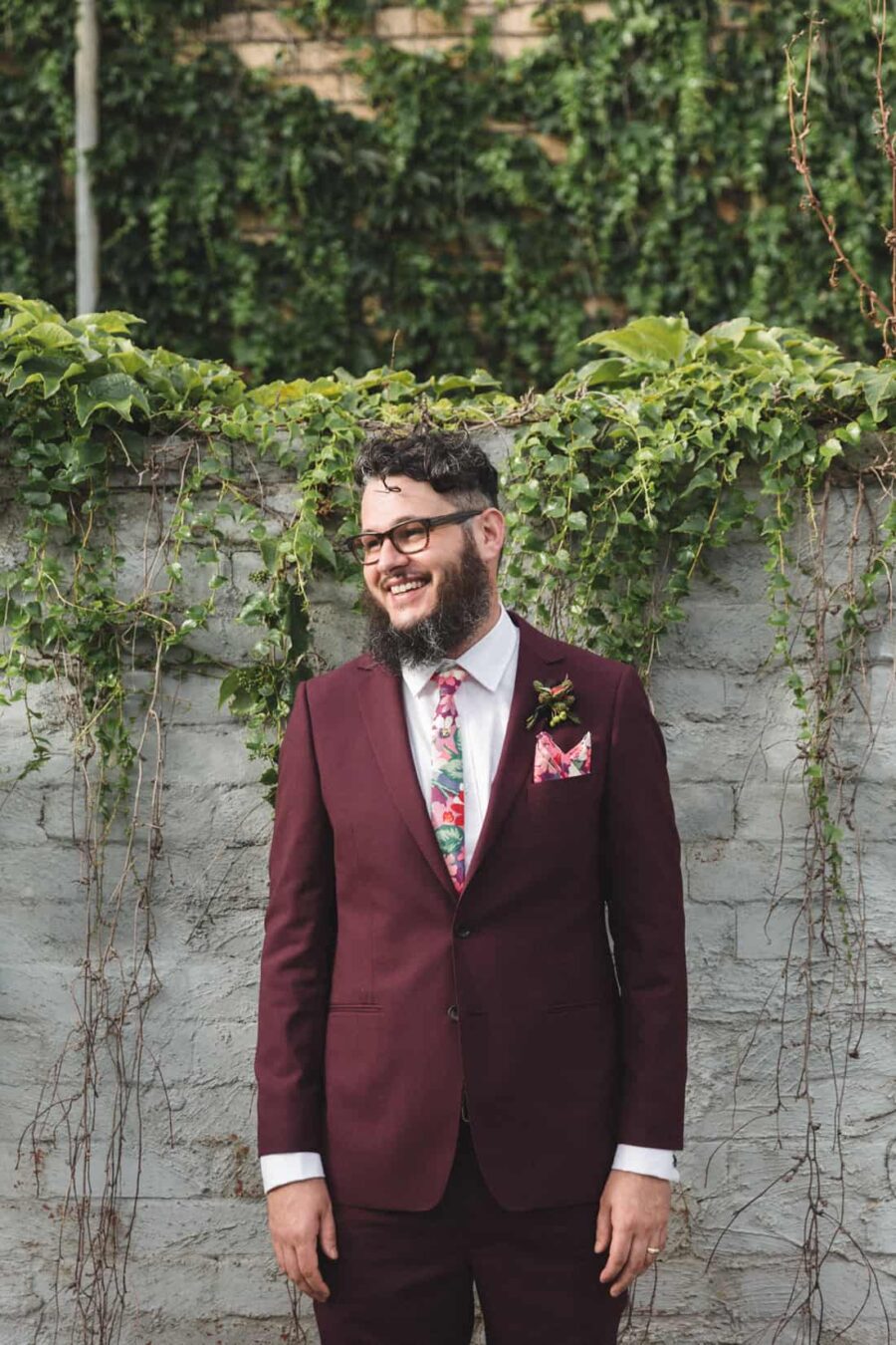 bearded groom in burgundy suit
