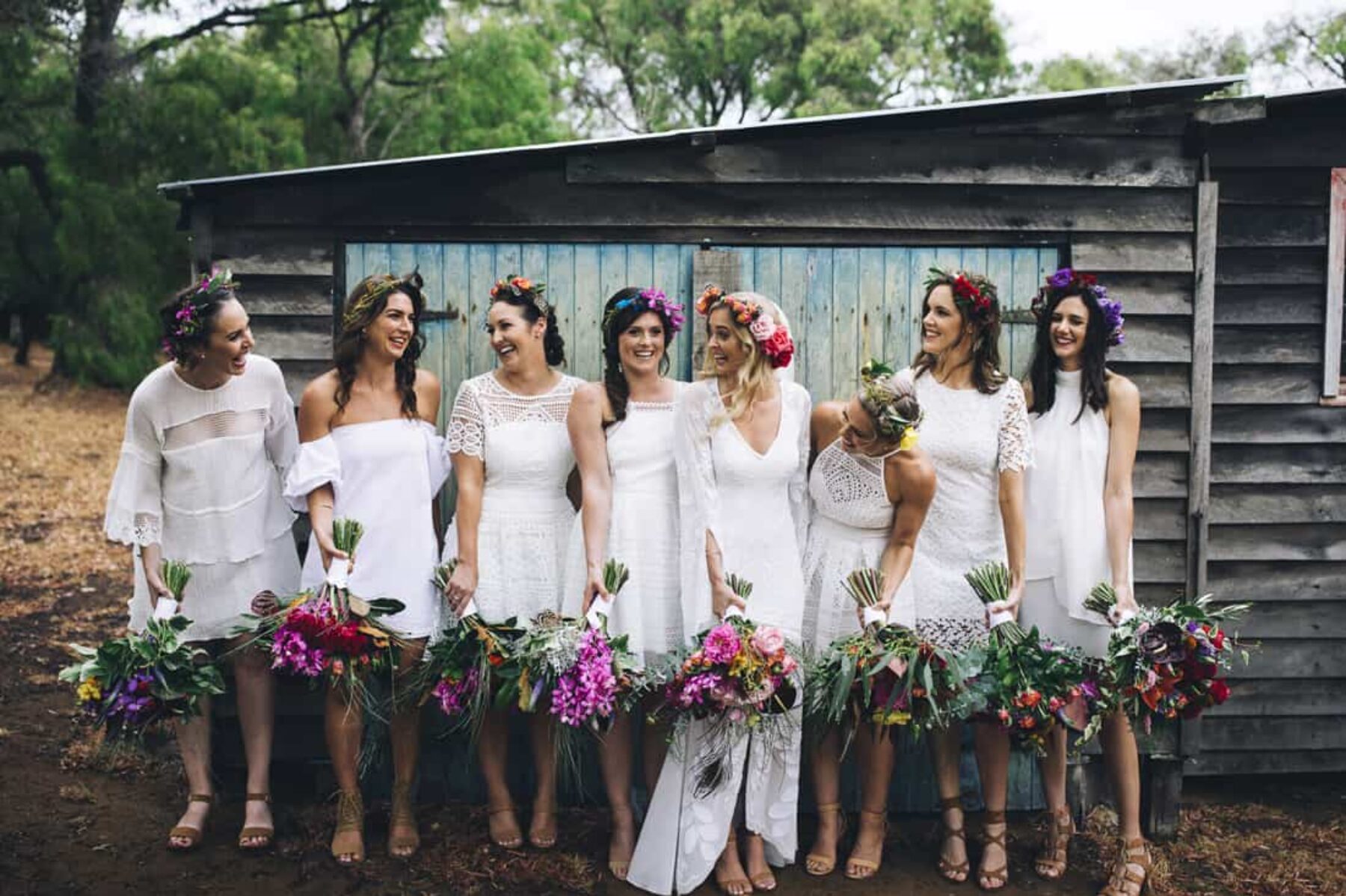 boho bridesmaids in mixed white dresses with vibrant bouquets