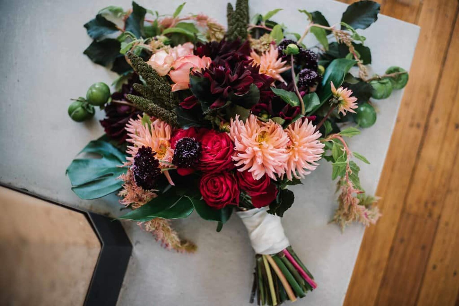 mixed pink bridal bouquet with dahlias and monstera leaf