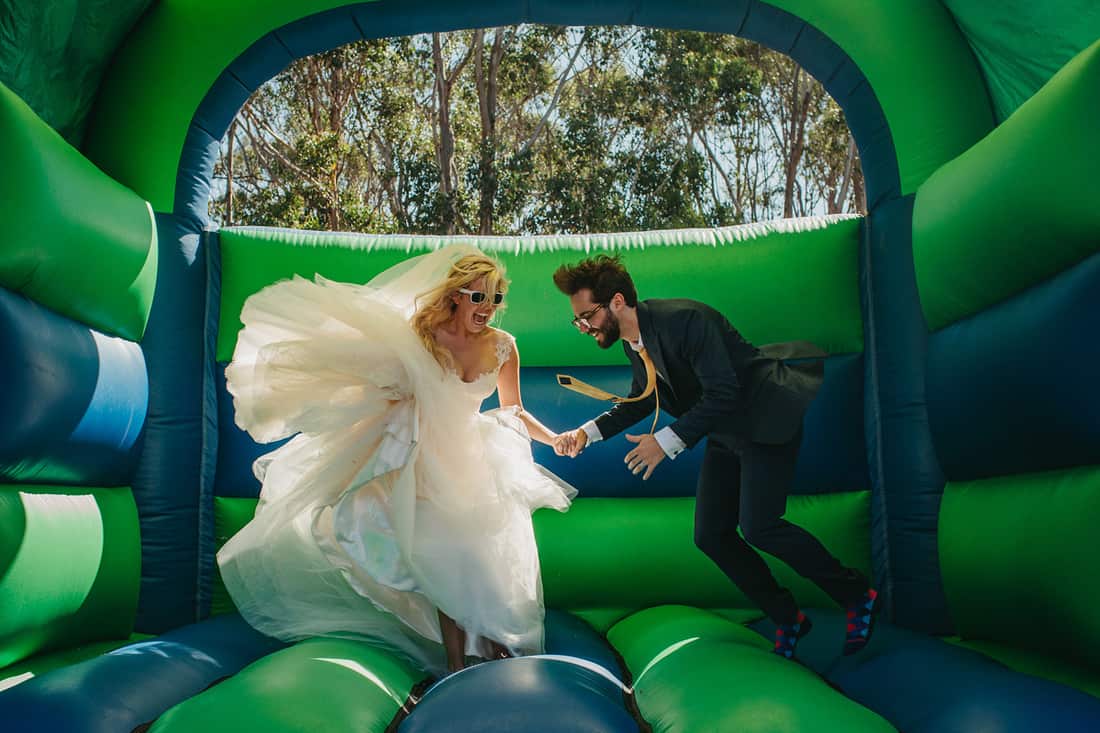 bride and groom on bouncey castle - photography by Stories by Ash