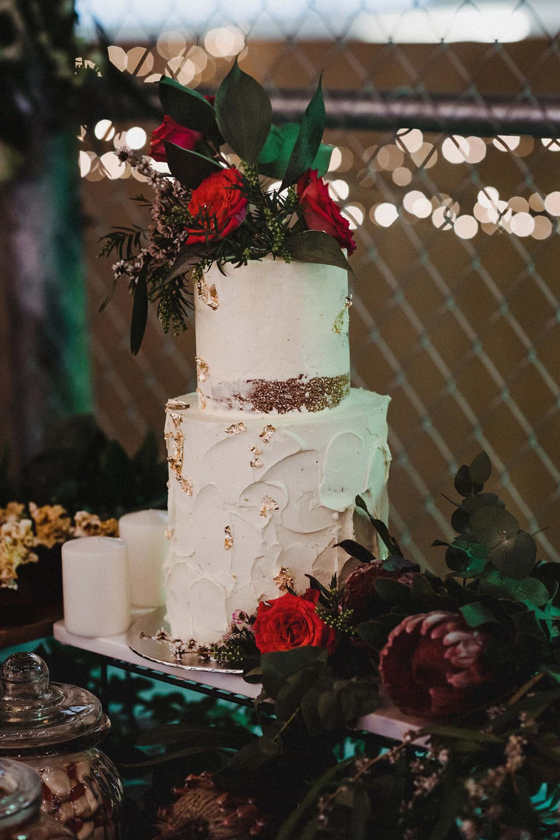 textured two-tiered wedding cake with fresh roses