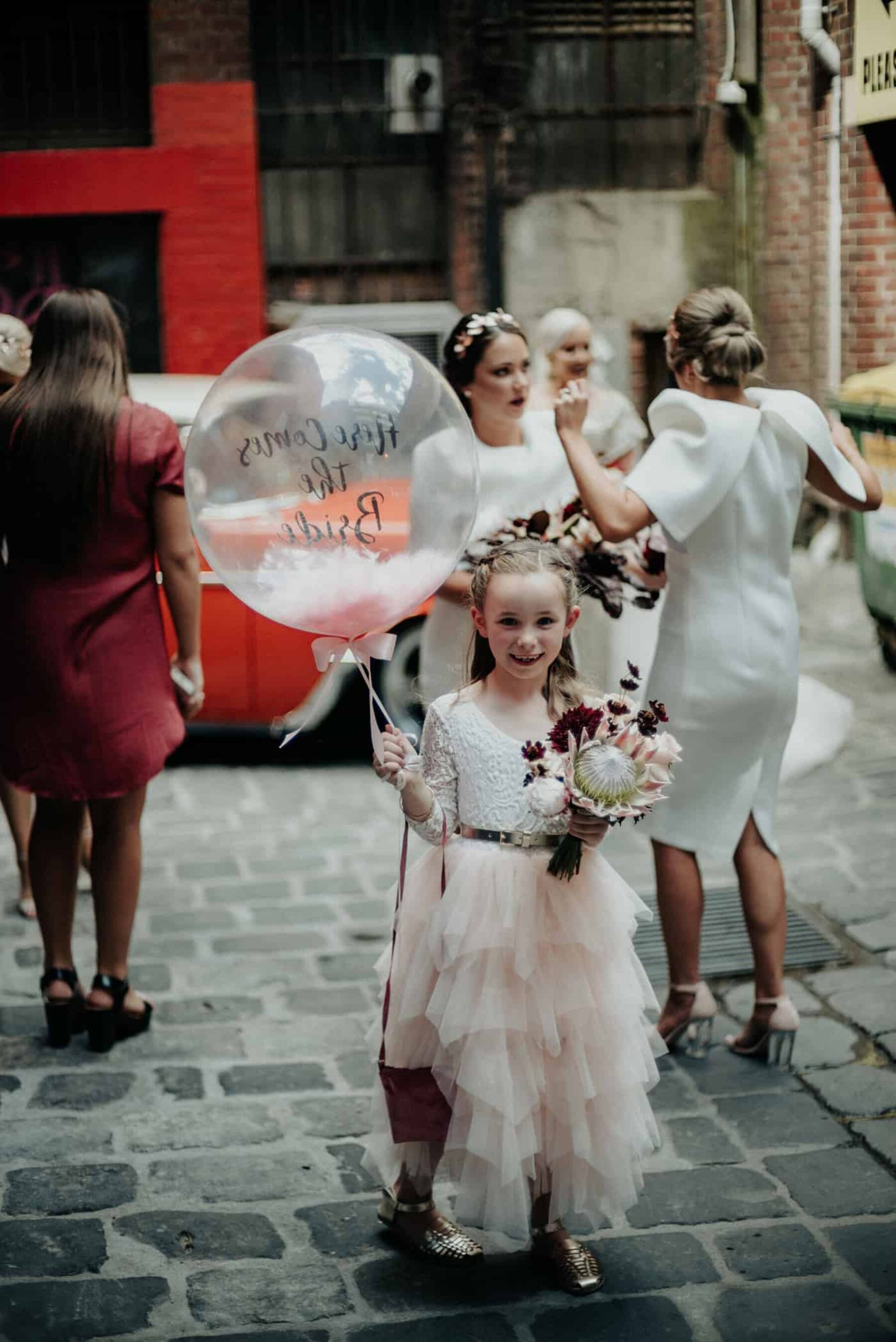 flower girl with 'here comes the bride' confetti balloon