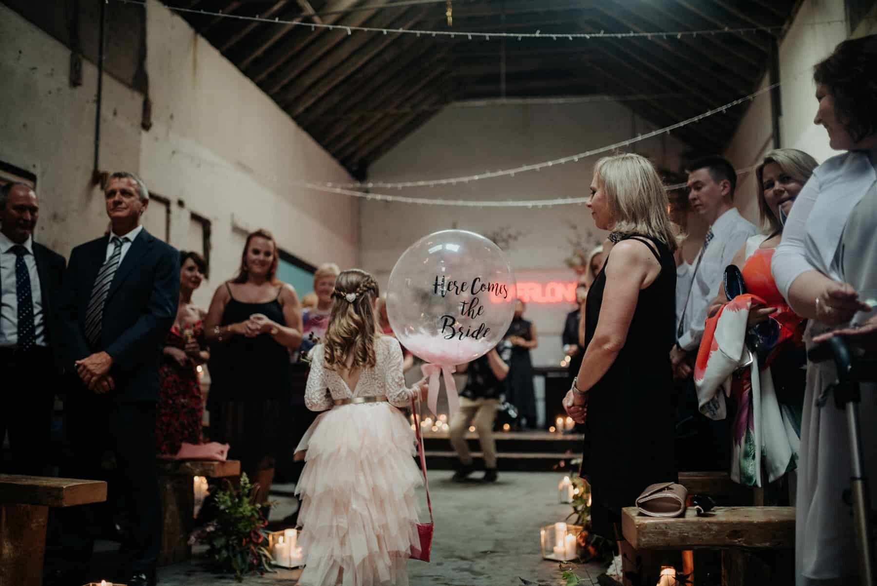 flower girl with 'here comes the bride' confetti balloon