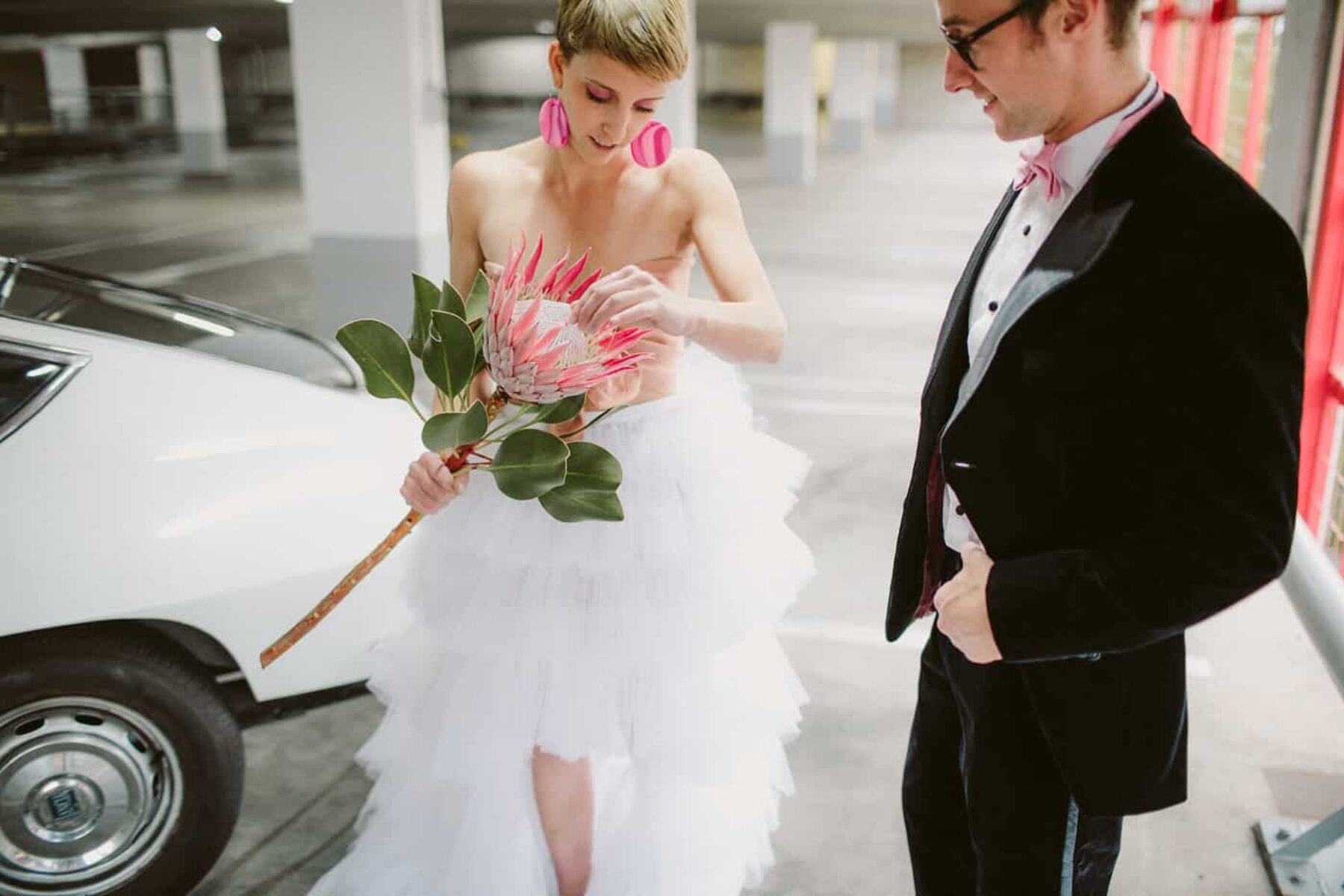 quirky bride and groom with single king protea bouquet