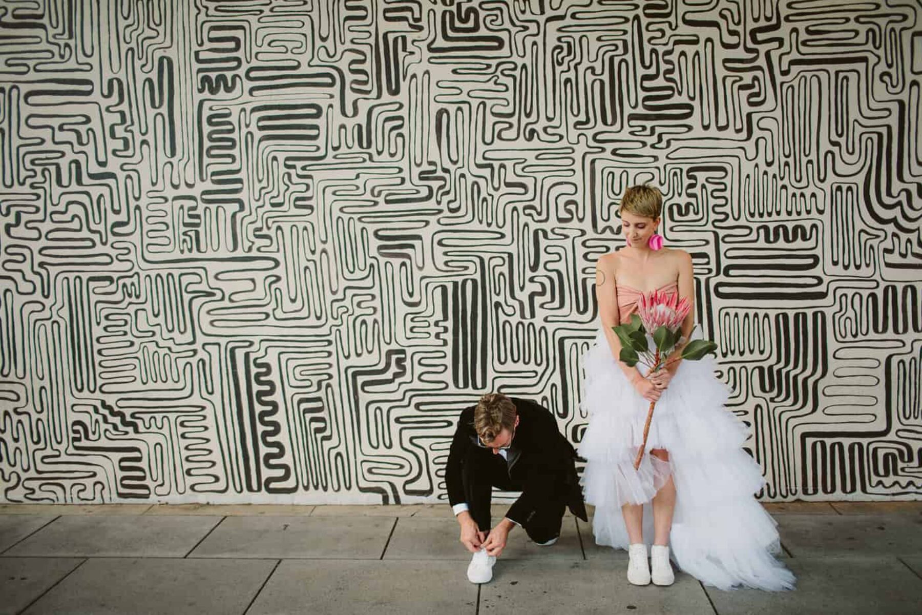 quirky bride and groom with street art back drop