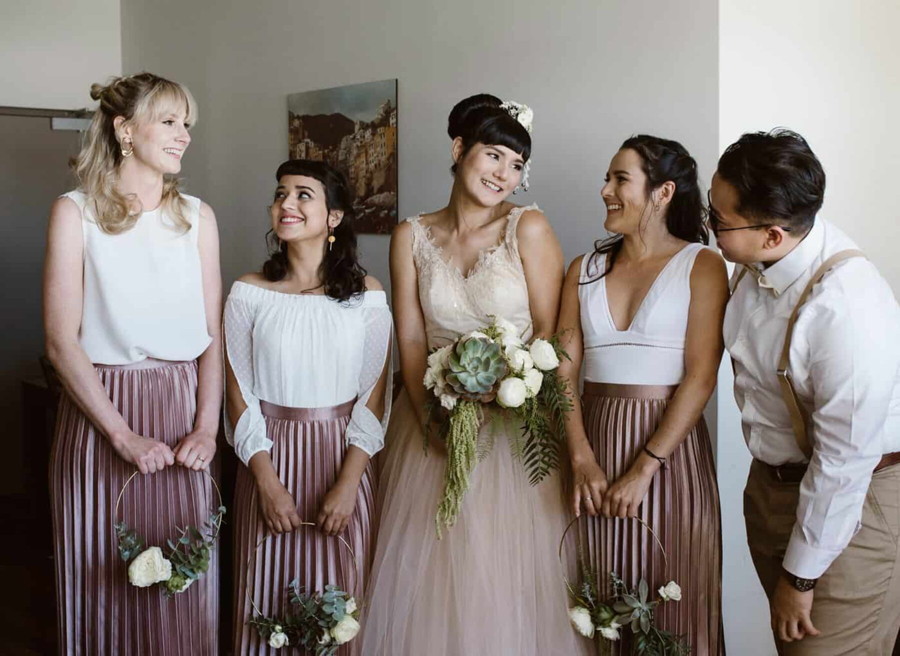 bridesmaids in dusty pink pleated skirts and white tops