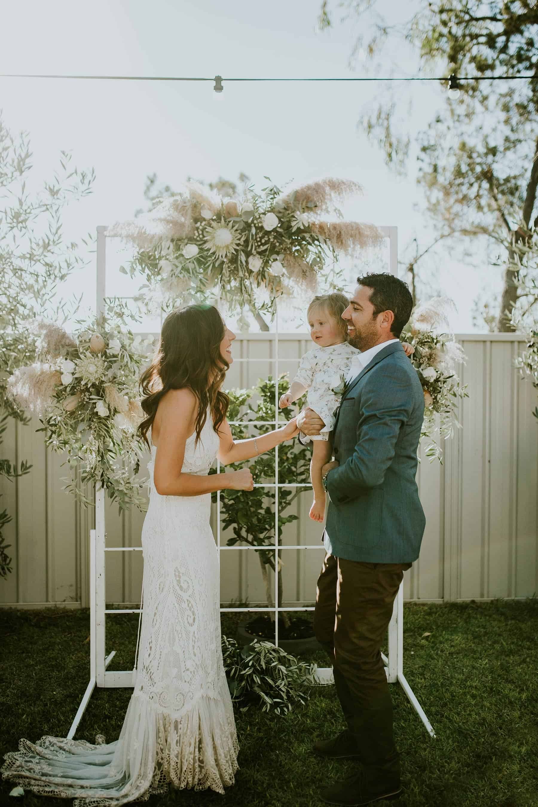 backyard wedding with white floral arbour