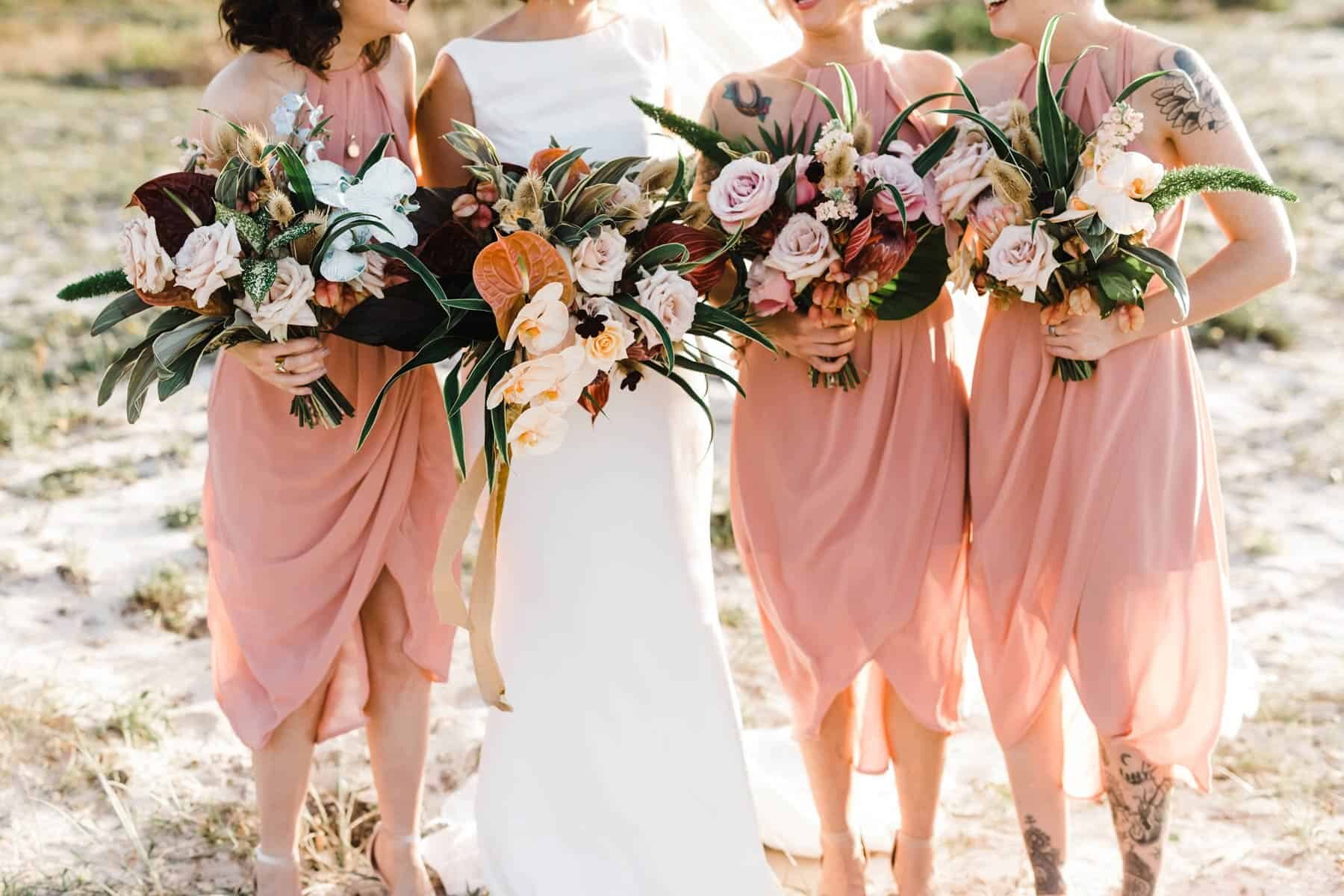 blush bridesmaid dresses and tropical bouquets