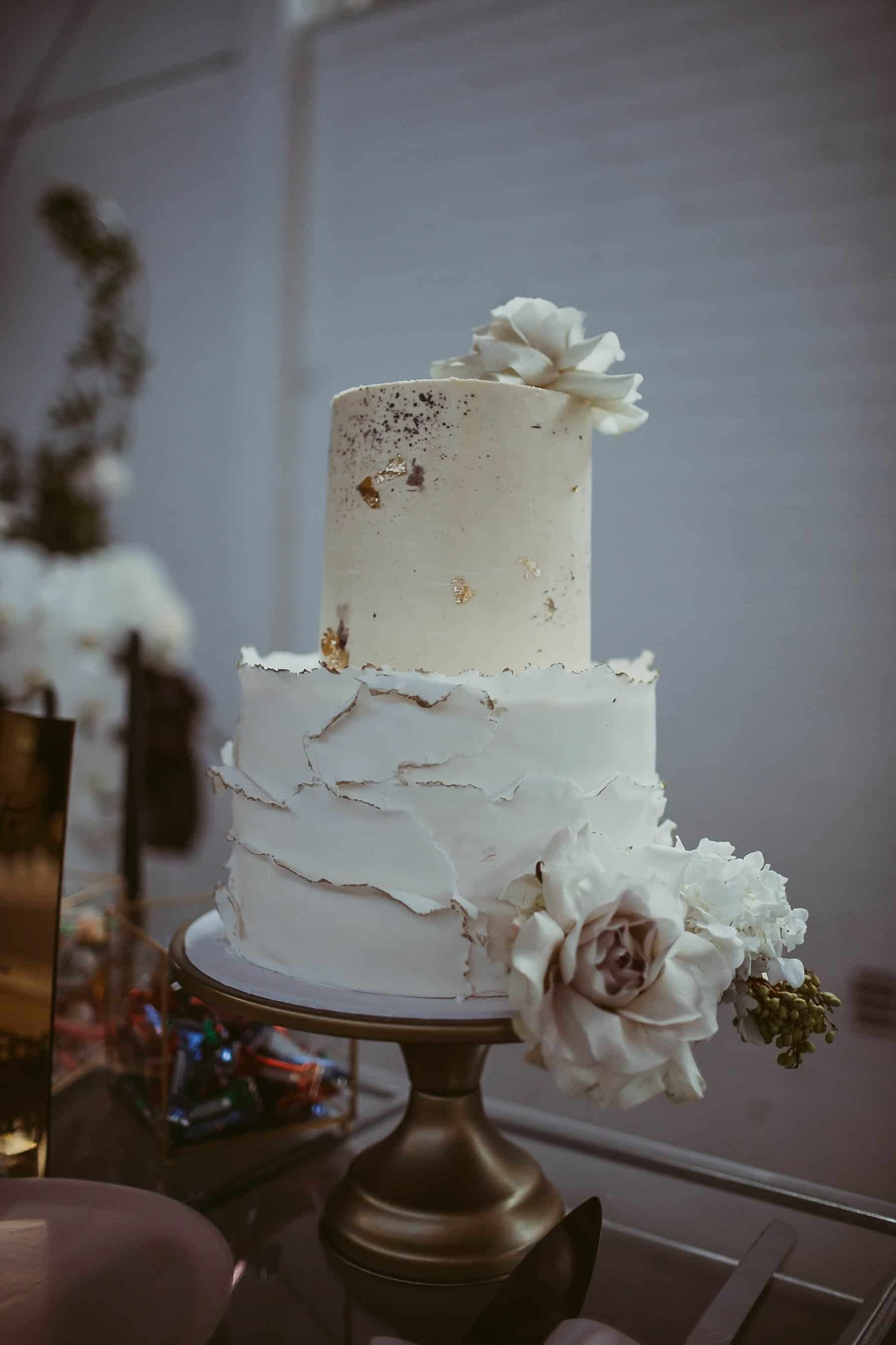 white two tier wedding cake with gold leaf