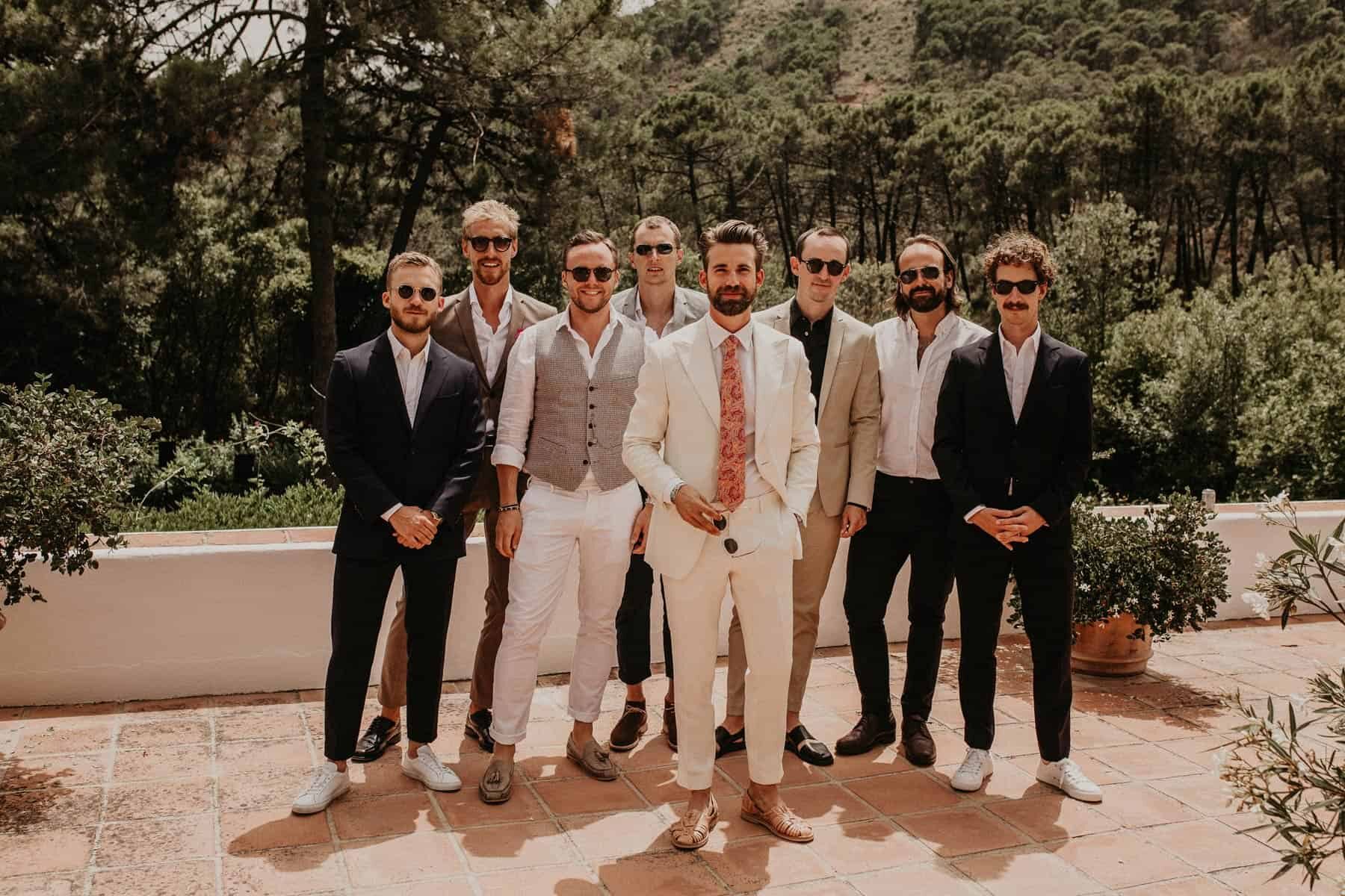 groom in white suit and mismatched groomsmen