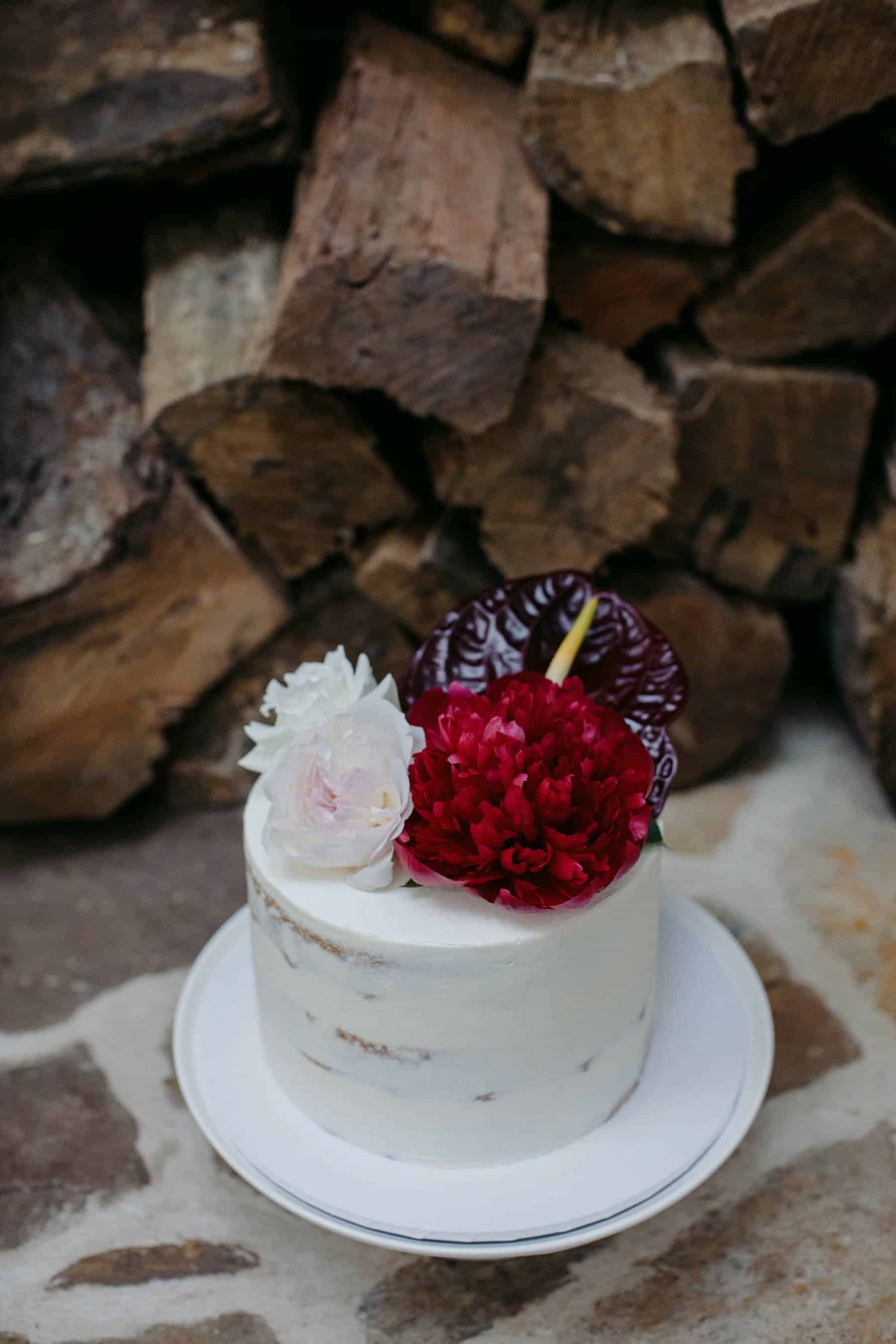 simple white cake with blush and burgundy flowers