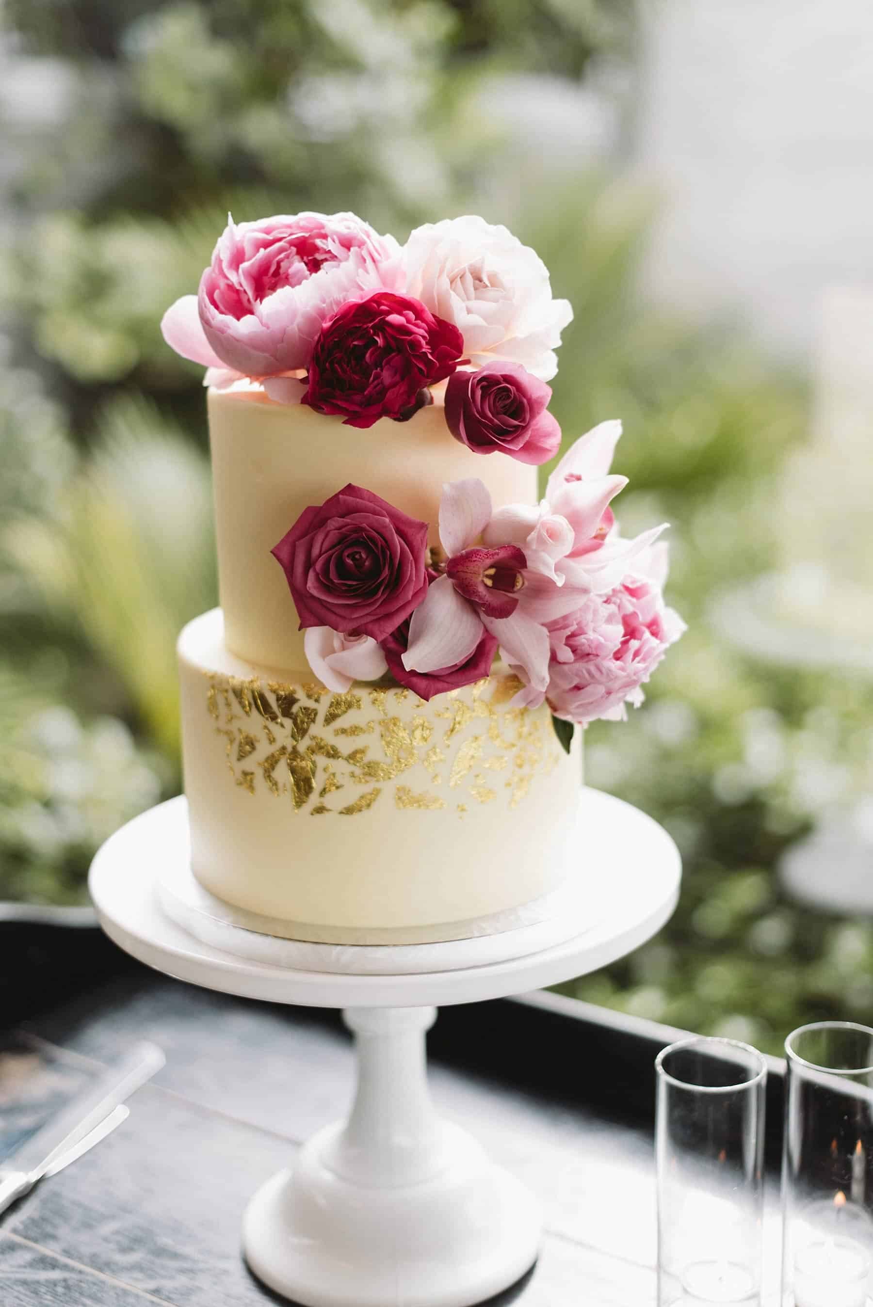 simple white gold-flecked wedding cake with pink flowers