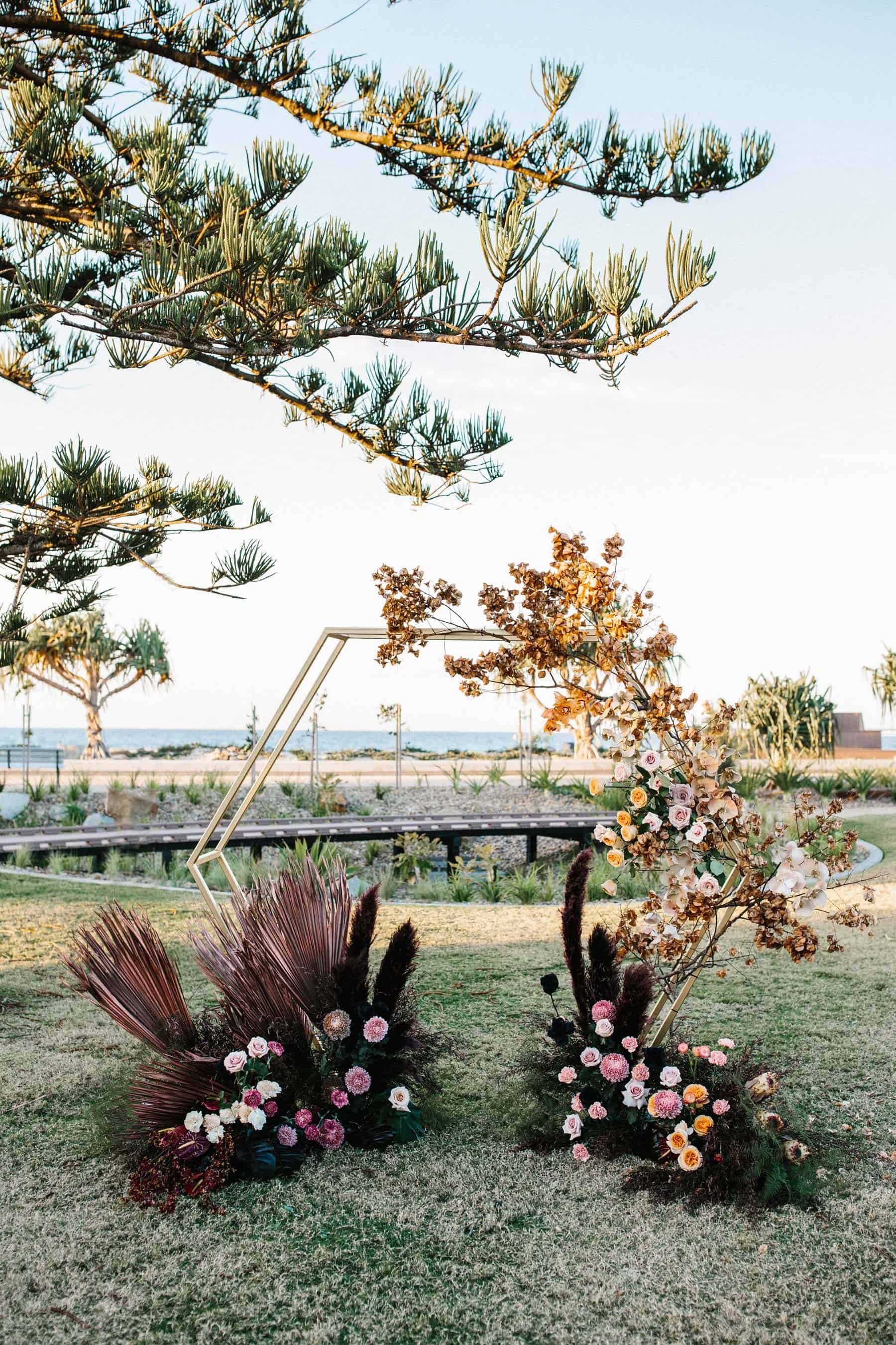 hexagonal wedding arbour with blush and burgundy florals