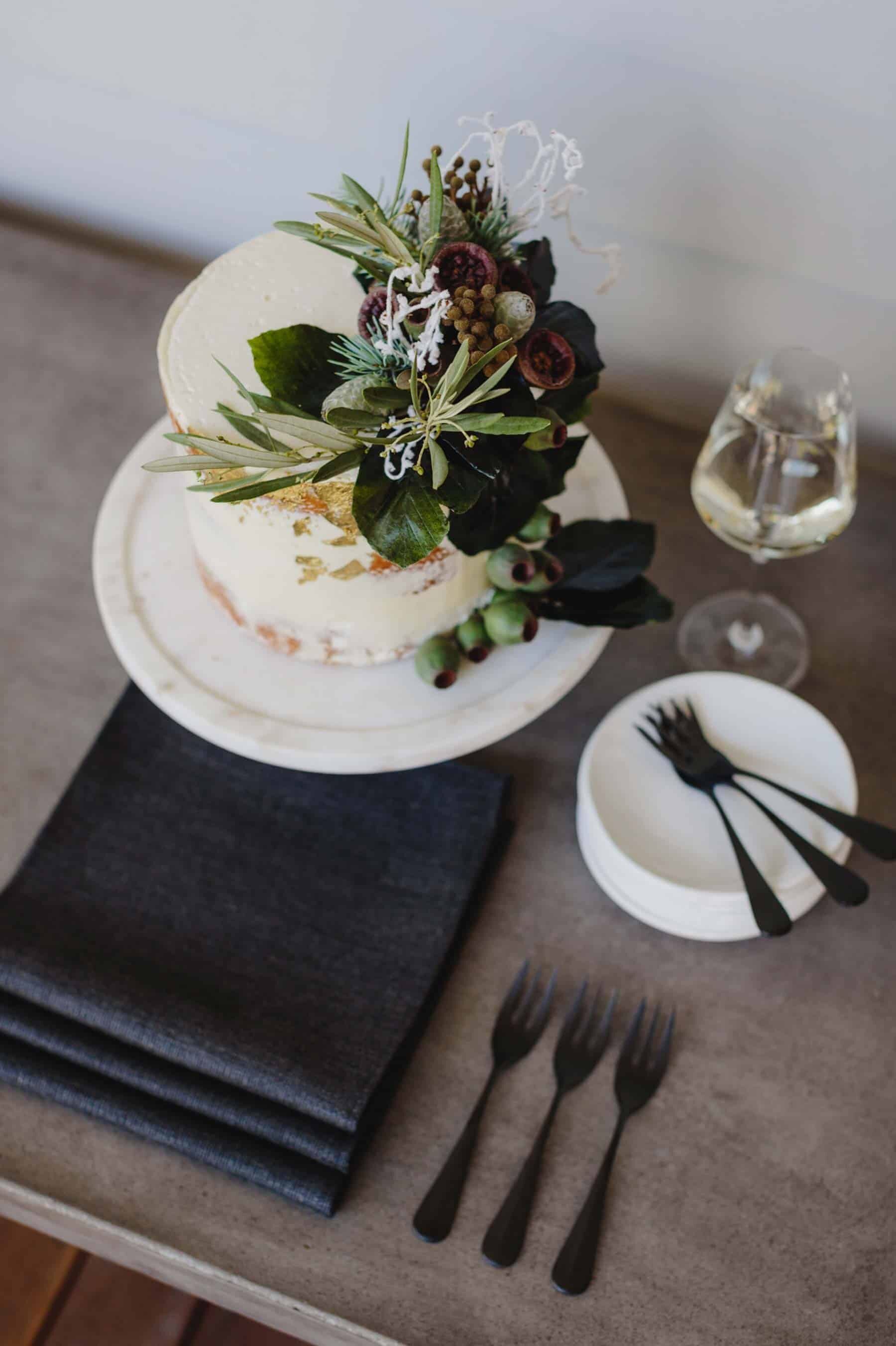 single tier cake topped with native Australian flowers and nuts