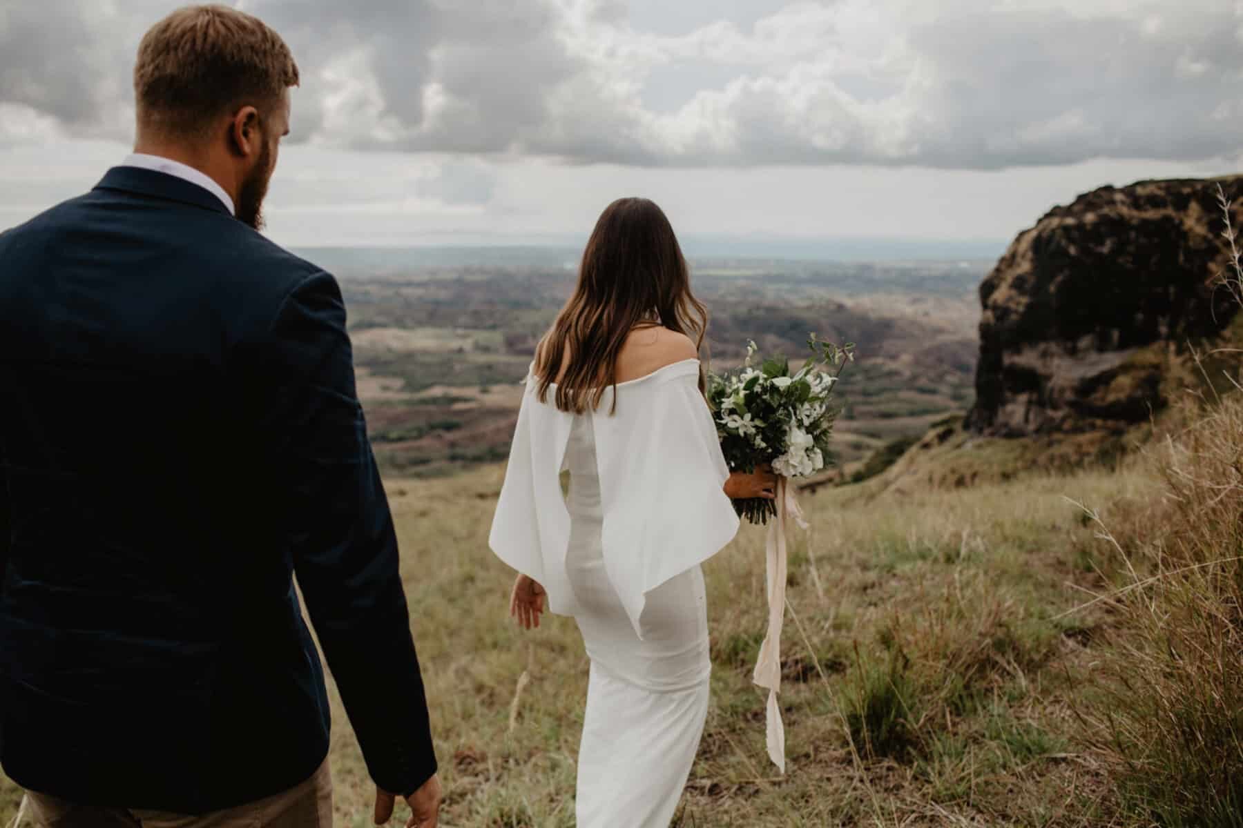 modern and minimal wedding dress with off-shoulder cape detail