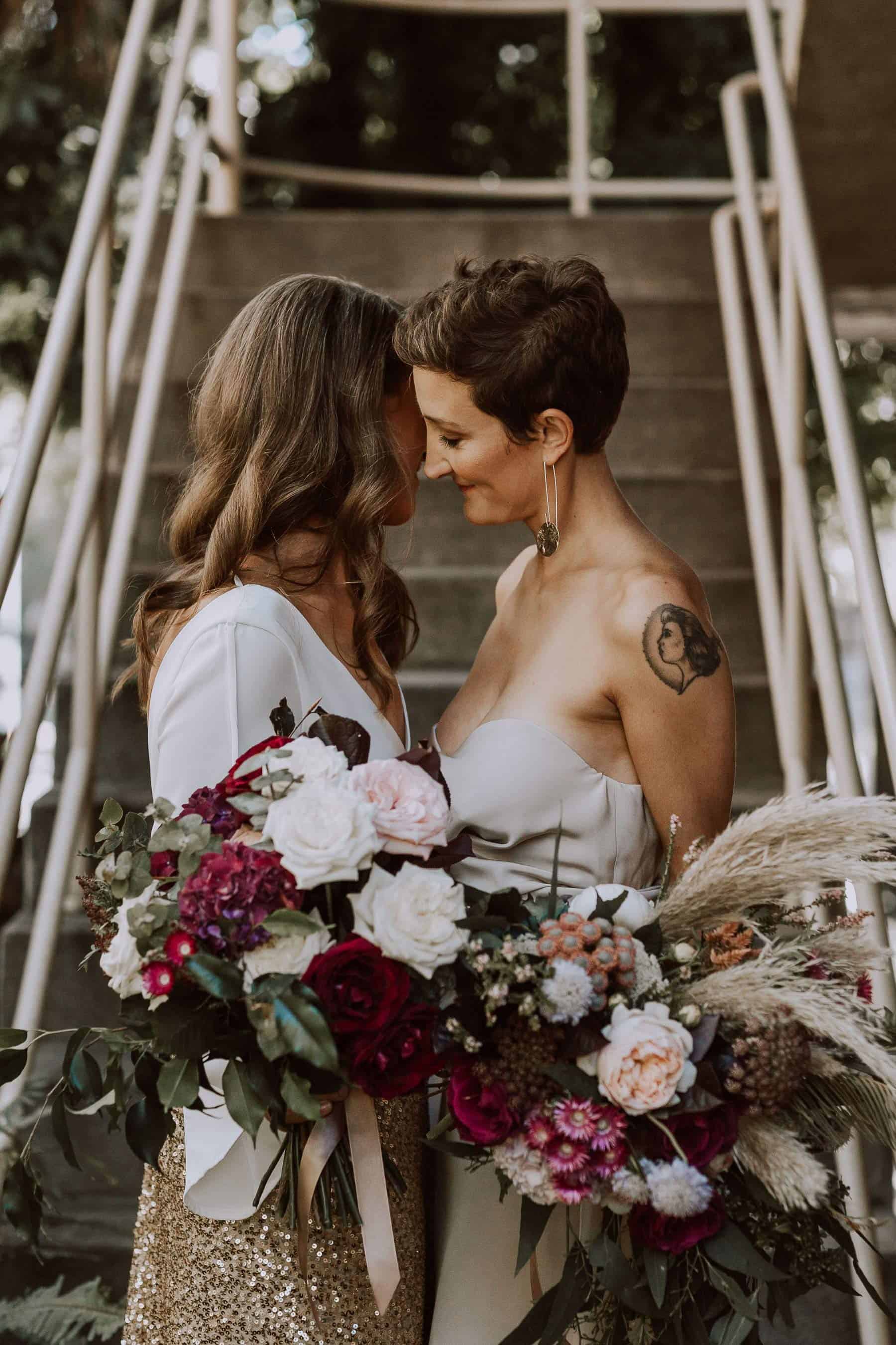two brides with blush and burgundy bouquets