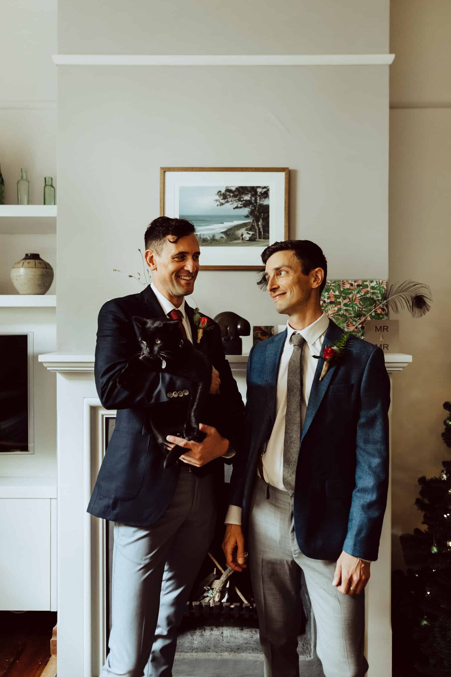 two grooms with their black cat