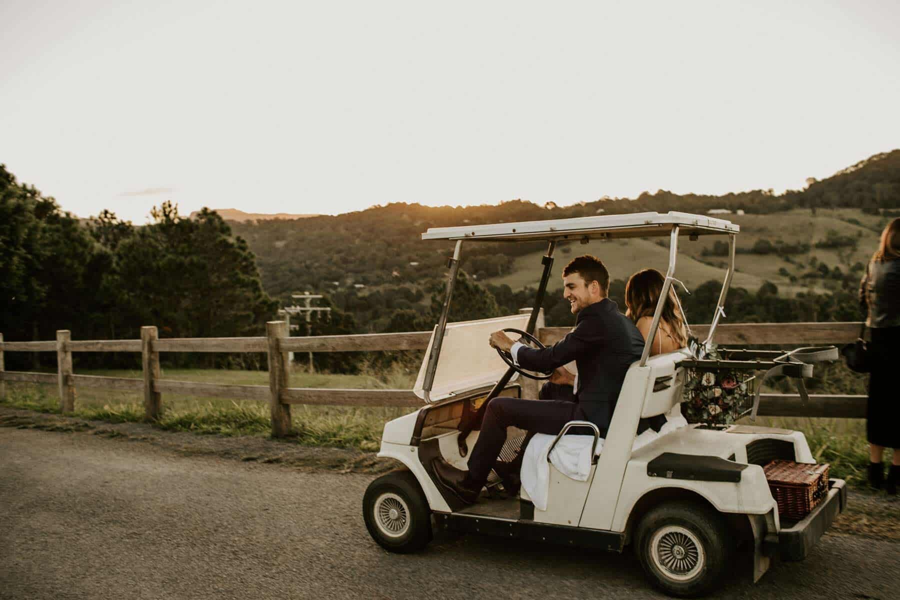 bride and groom in golf buggy