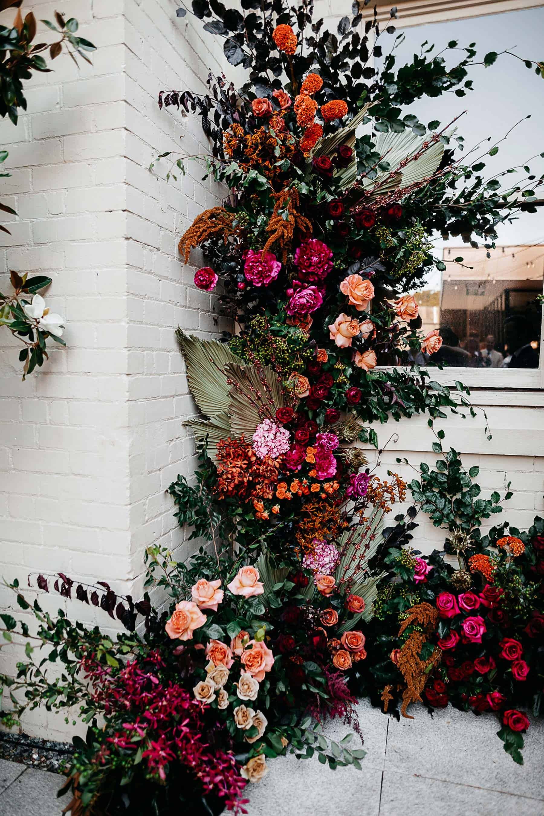 Vibrant climbing flower wall for wedding ceremony