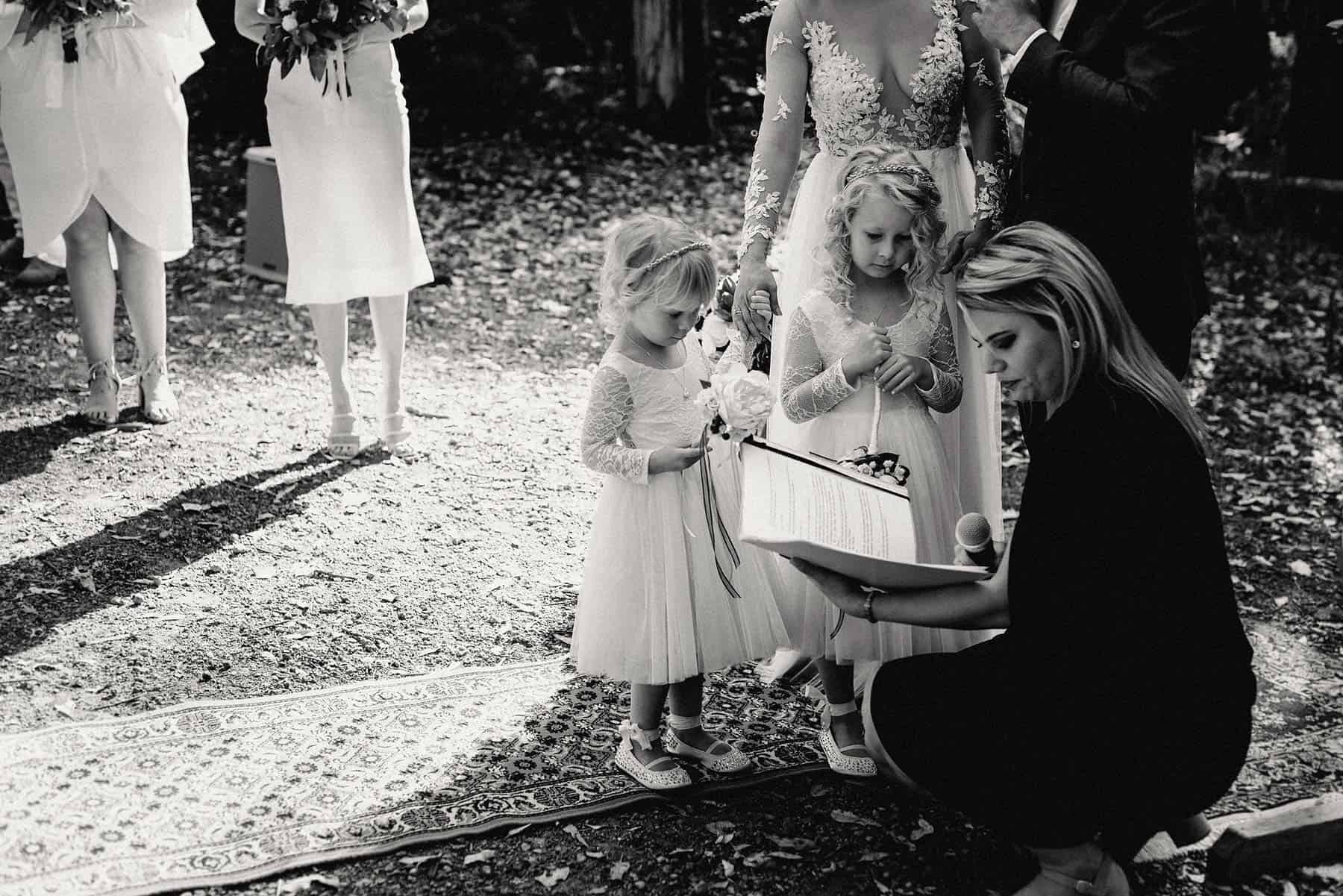 Celebrant includes flower girls in ceremony at rustic forest wedding