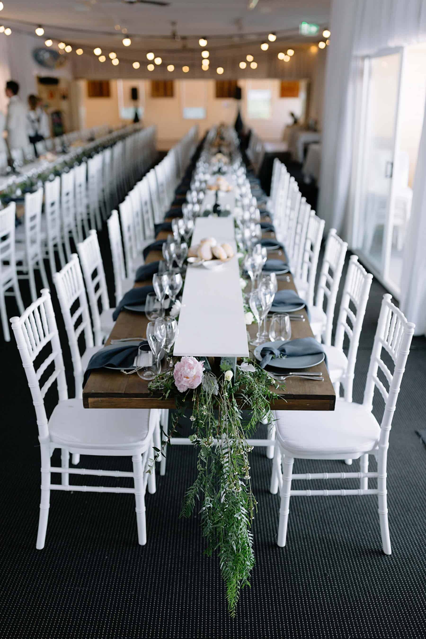 long wedding table with white chairs