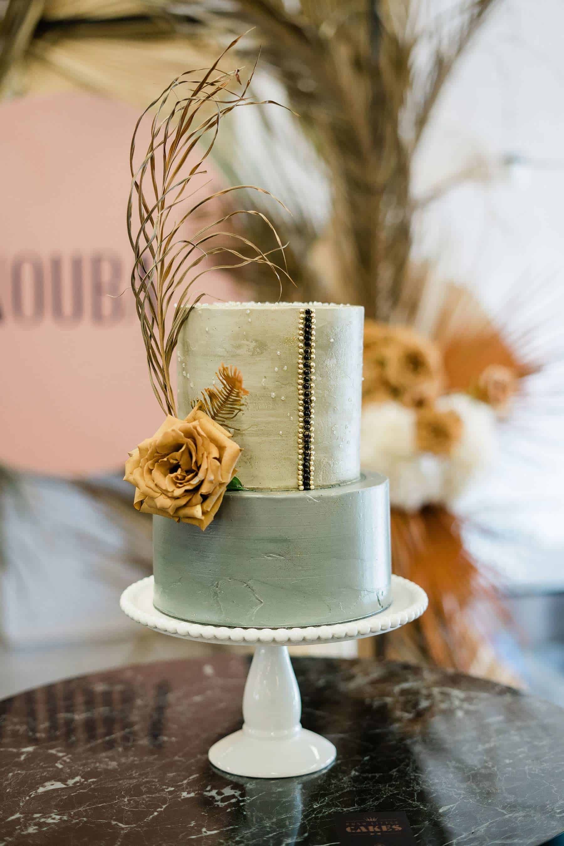 modern silver wedding cake with toffee rose and dried leaf topper