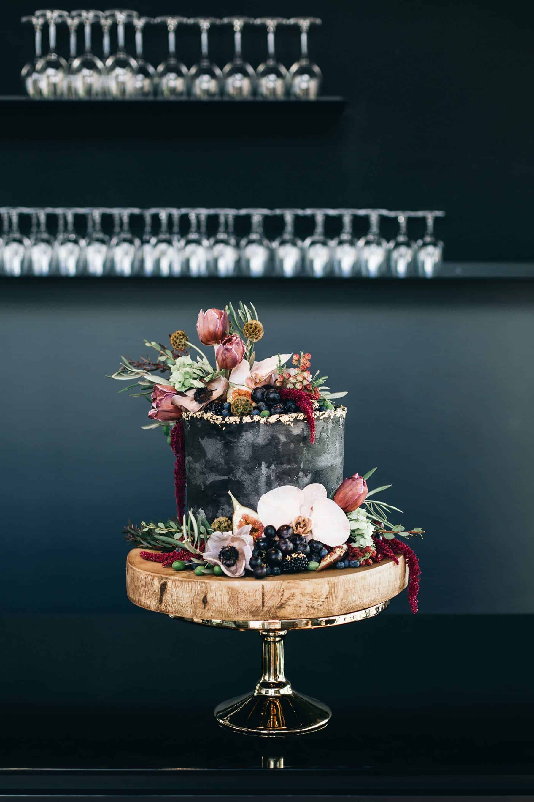 black wedding cake with fresh flowers