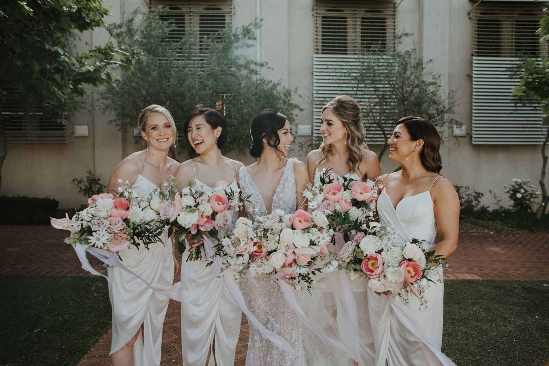 bridesmaids in white with soft pink bouquets