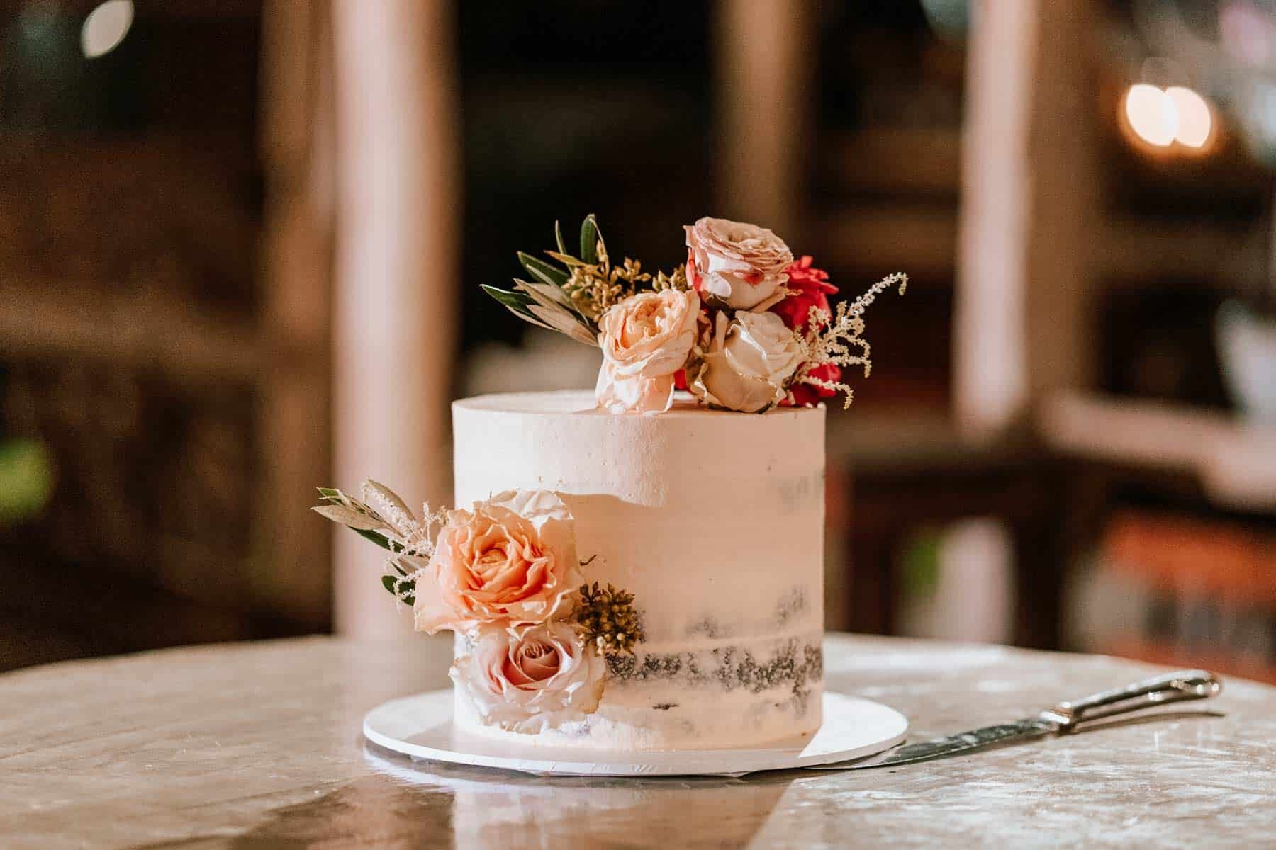 simple wedding cake with peach-toned flowers