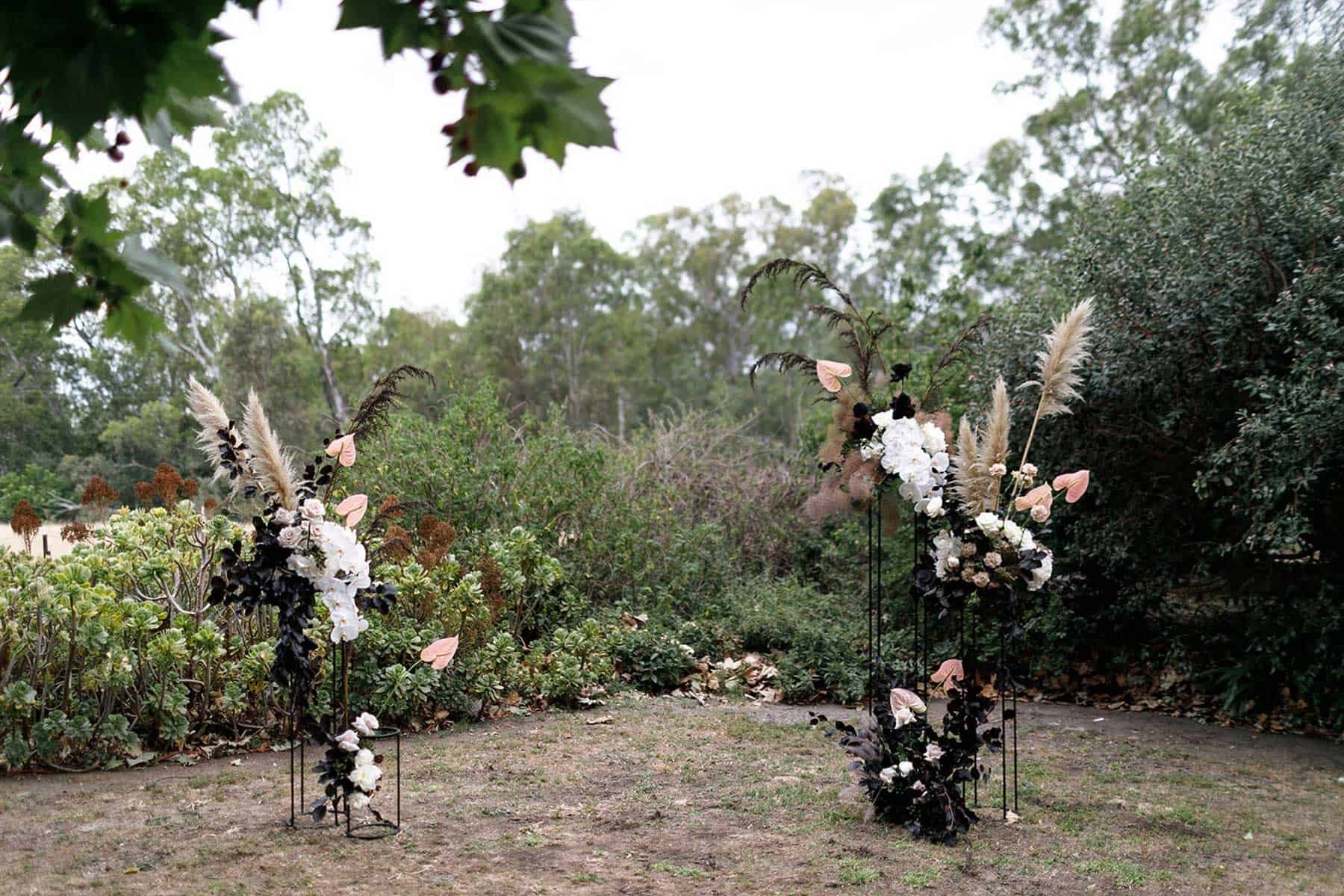 modern floral wedding backdrop with wire plinths