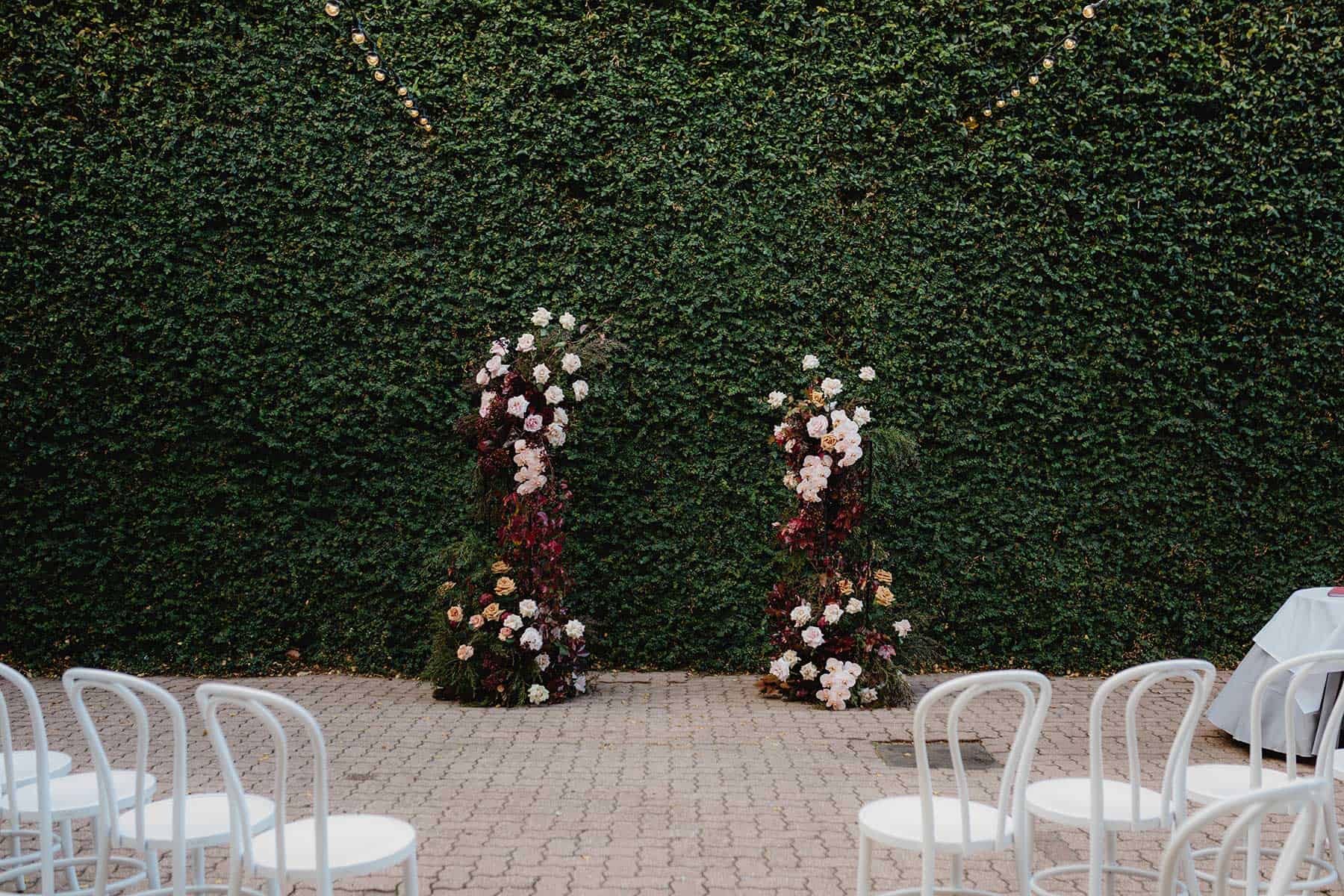 floral wedding arbour against green ivy wall