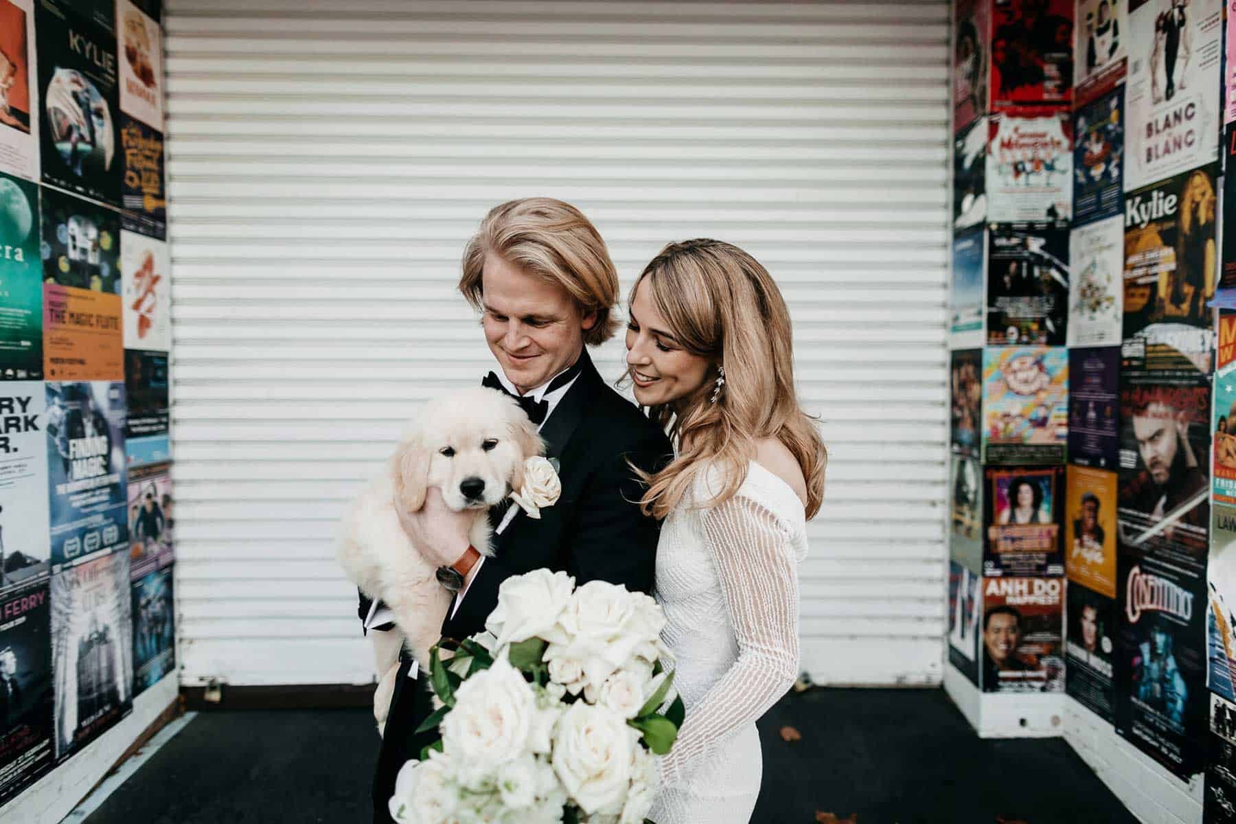 bride and groom with puppy