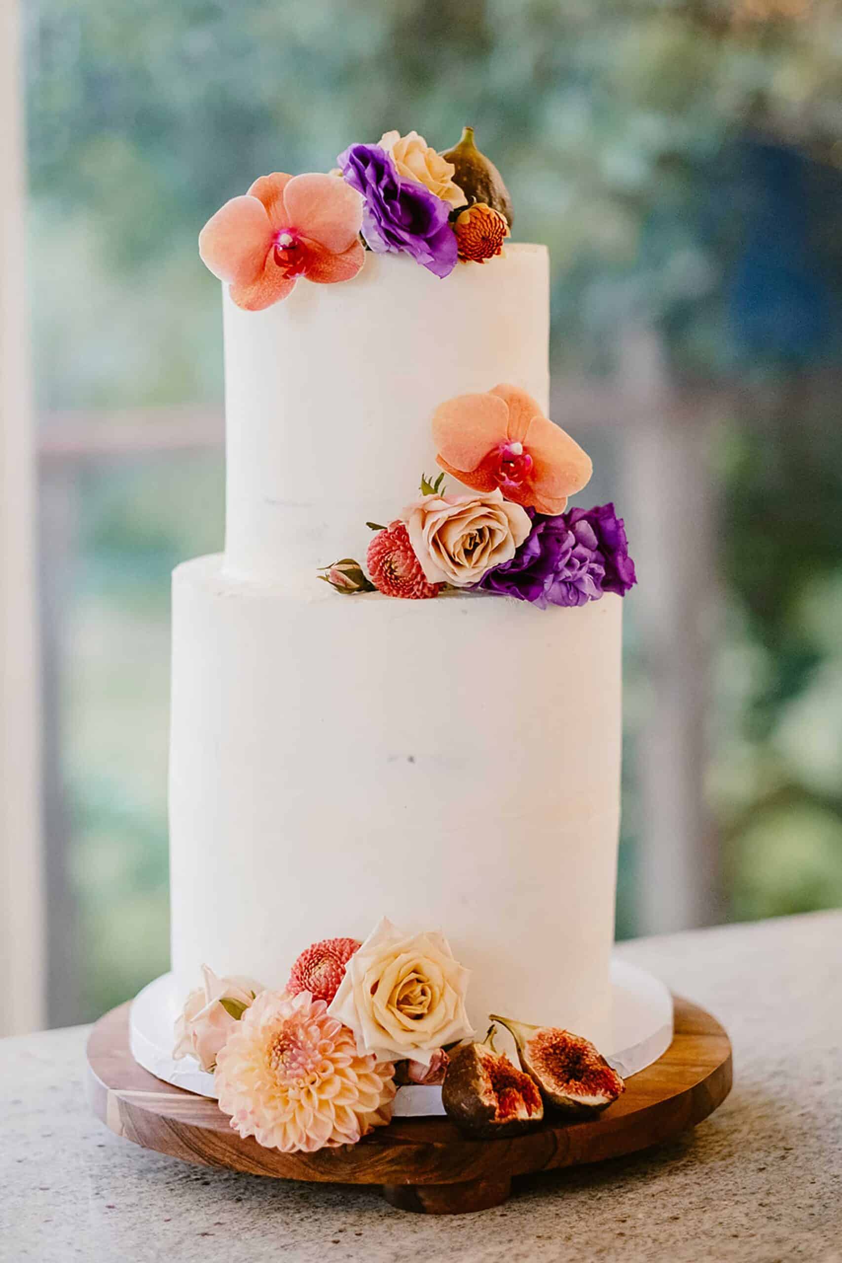 modern and minimal wedding cake with colourful fresh flowers