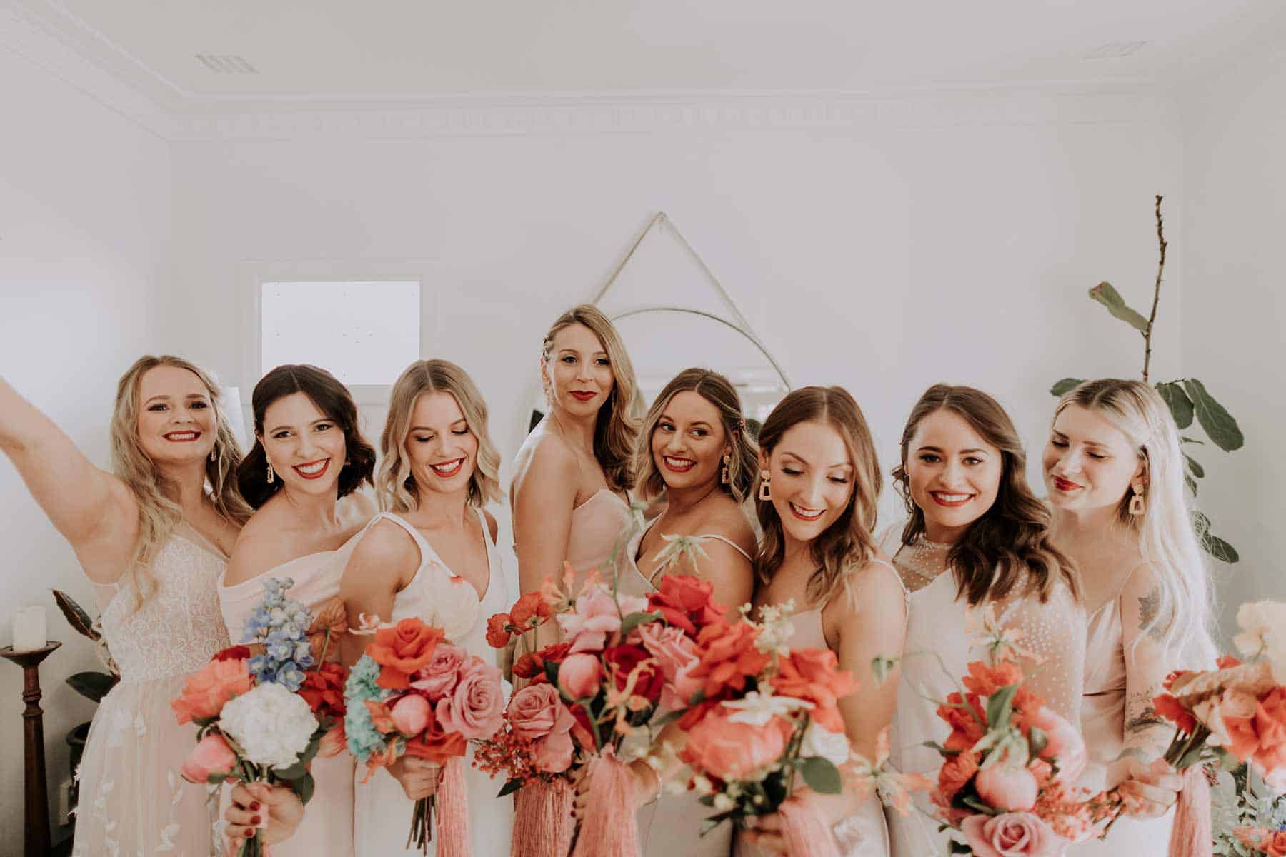 modern bridesmaids in mixed neutrals with colourful bouquets