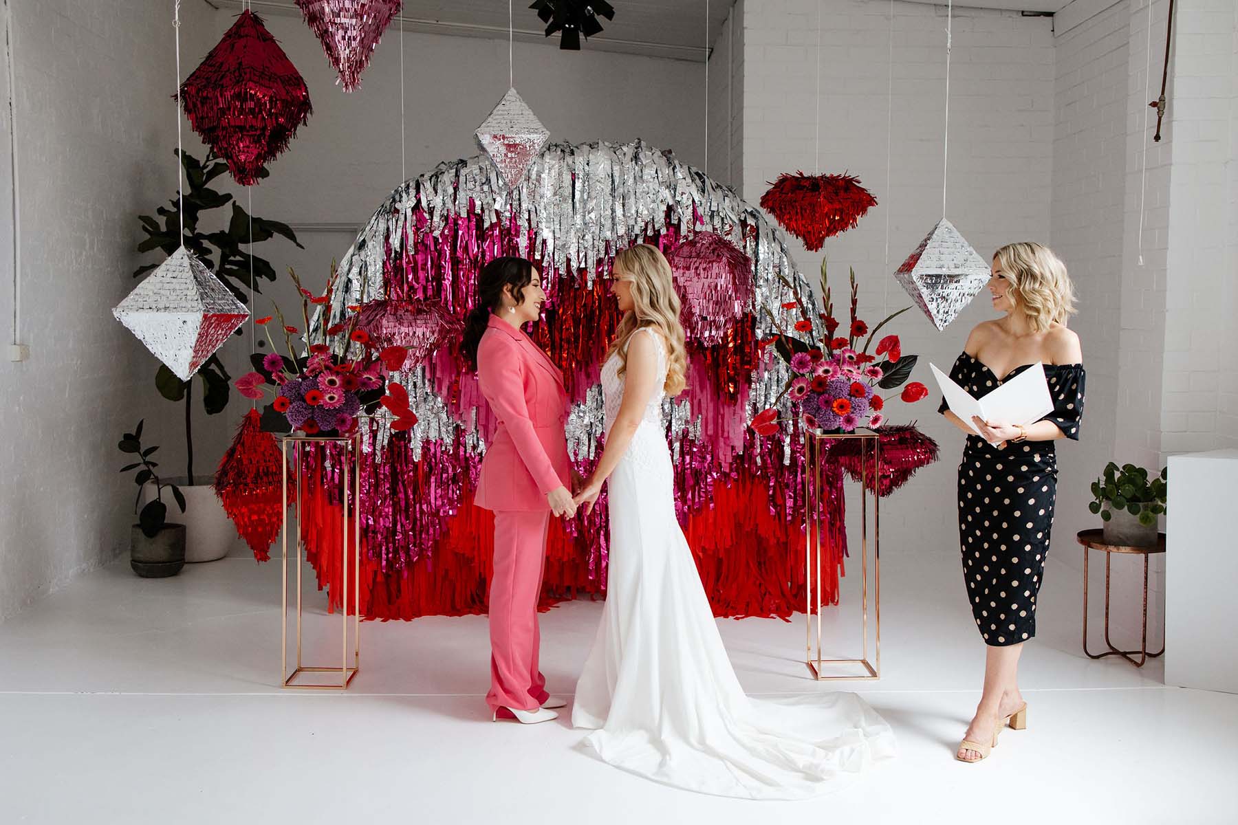 Pink wedding ceremony with streamer backdrop